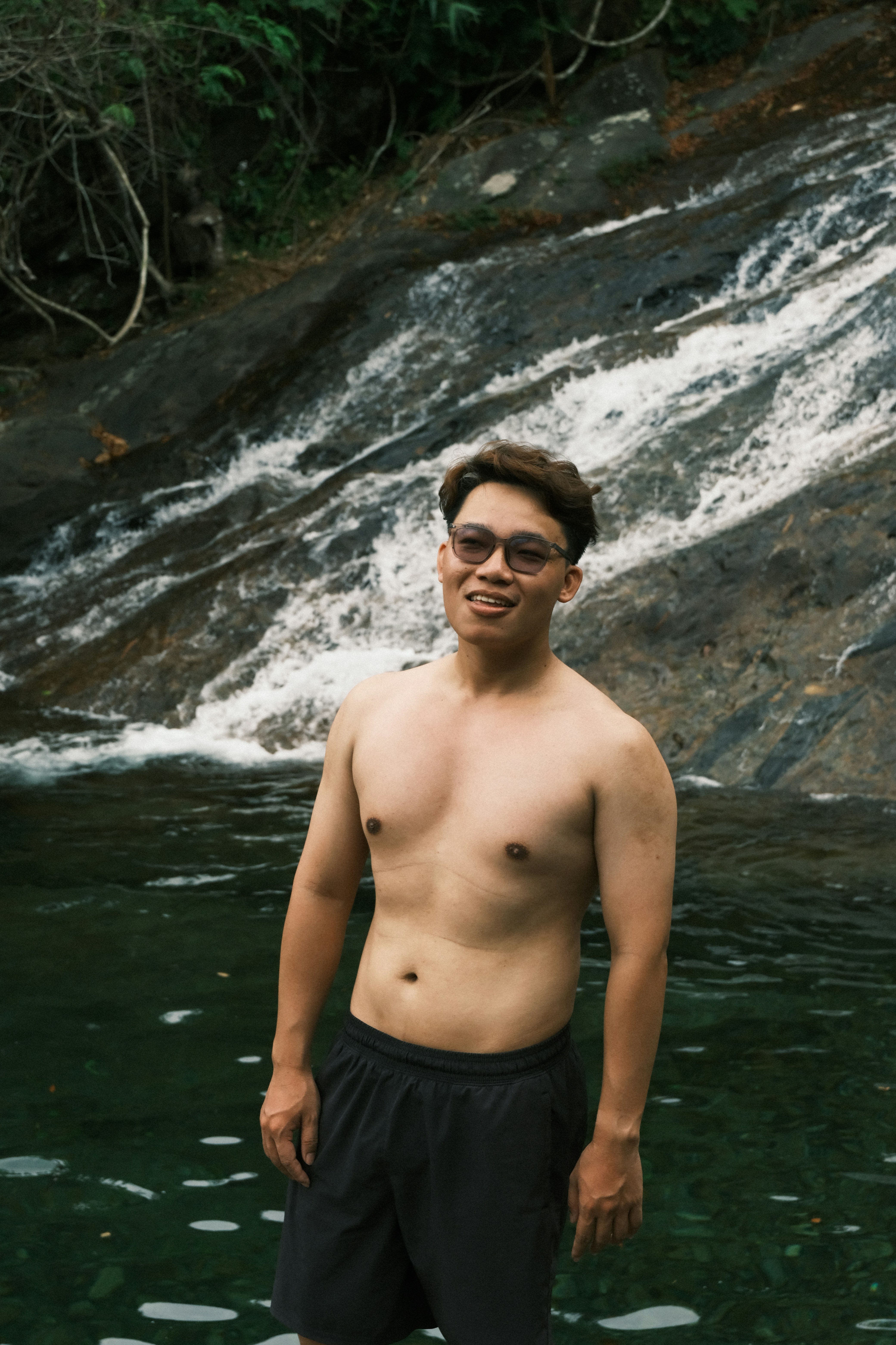 Homem parado na água perto de uma cachoeira