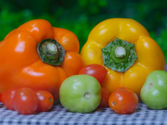 Orange and yellow bell peppers with tomatoes and tomatillos.