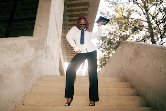 Woman in suit holding a book on stairs