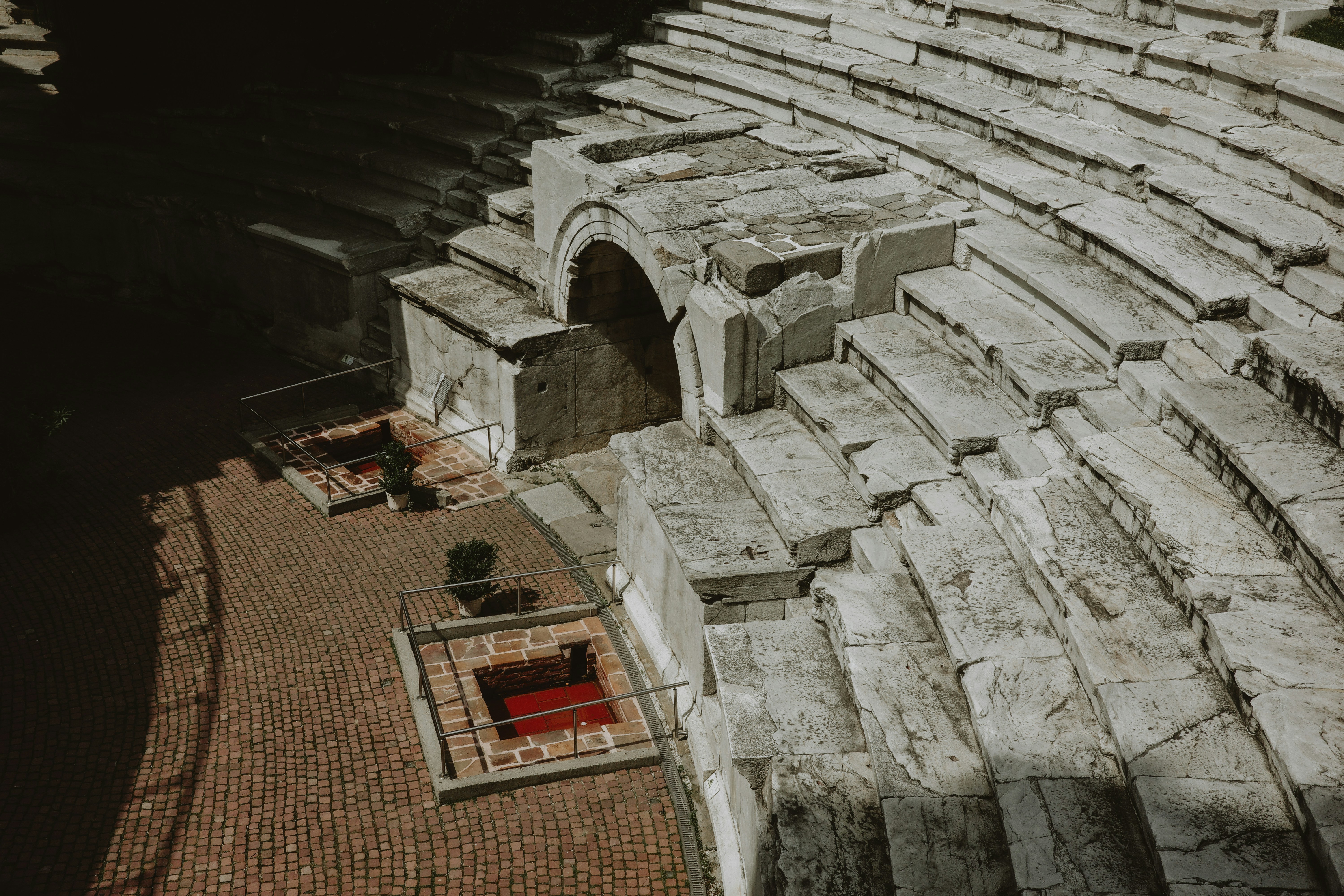 Ancient stone amphitheater seating with arched entrance