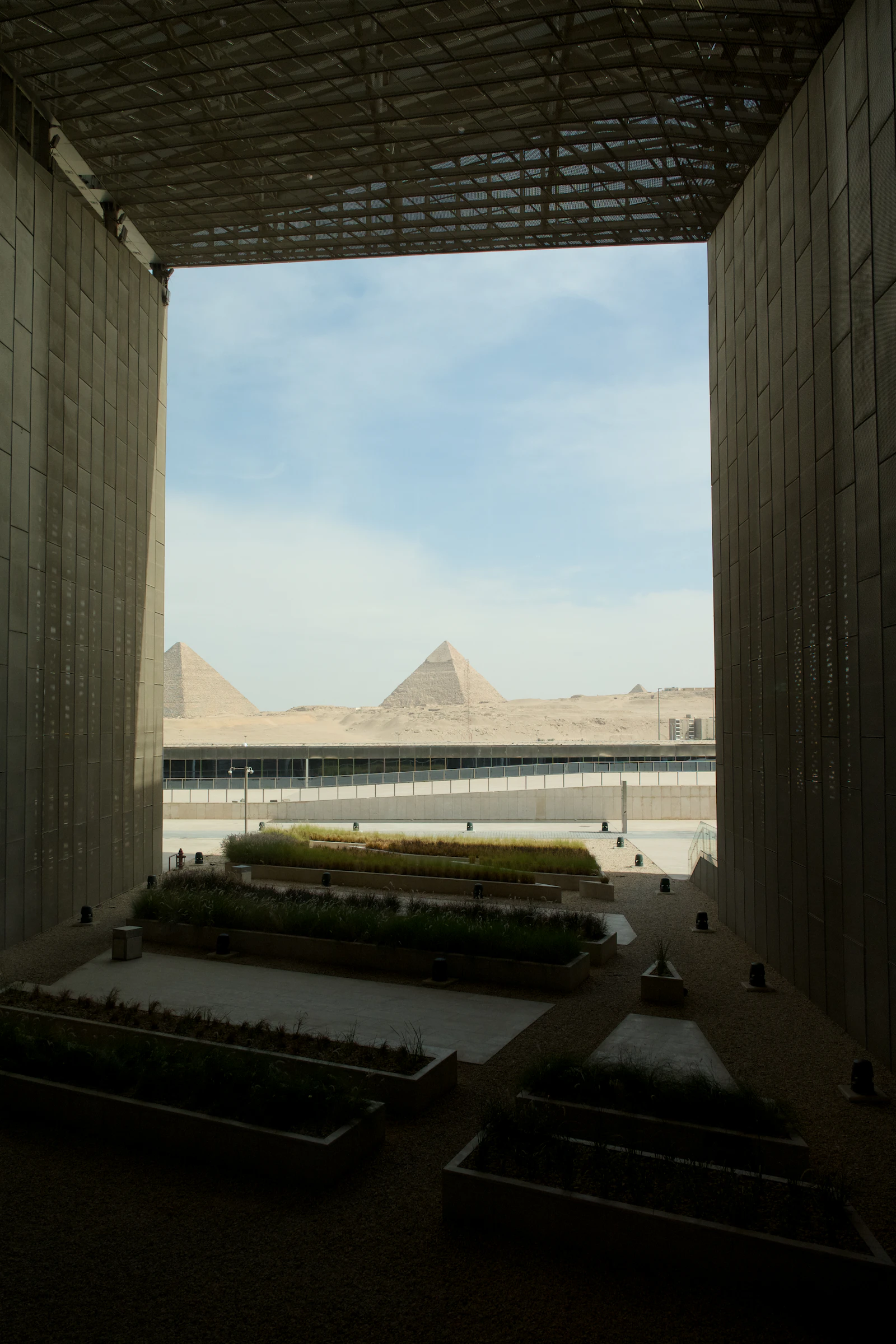 The Grand Egyptian Museum with the pyramids of Giza framed by its modern archway