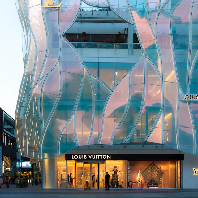 A modern Louis Vuitton building with a wavy white facade seen from street level