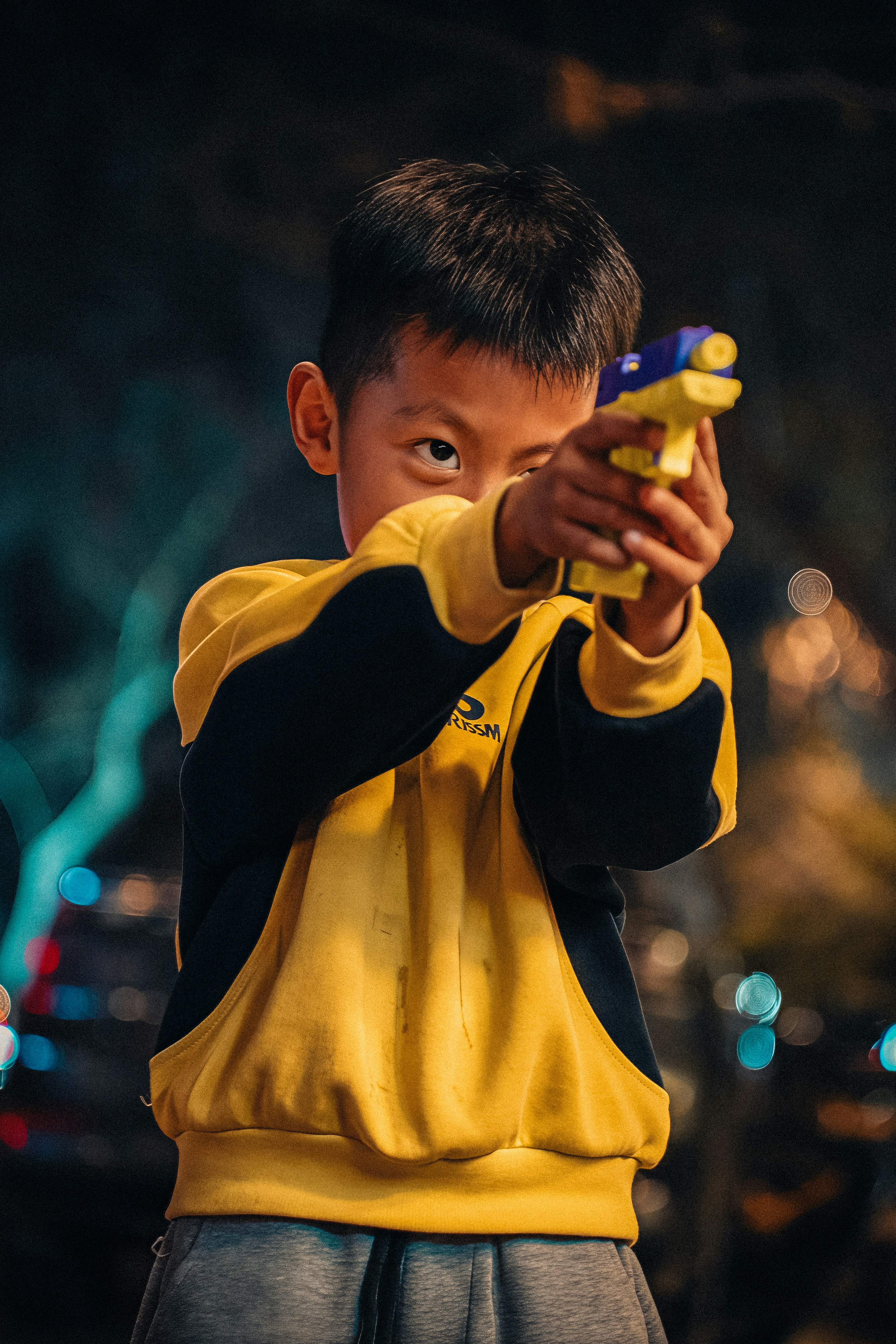 Young boy aiming a toy gun with focus