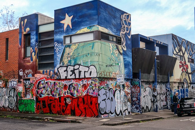 A building covered in bright graffiti art and murals, similar to the creative storefronts found along Main Street and Casino Center in the Arts District
