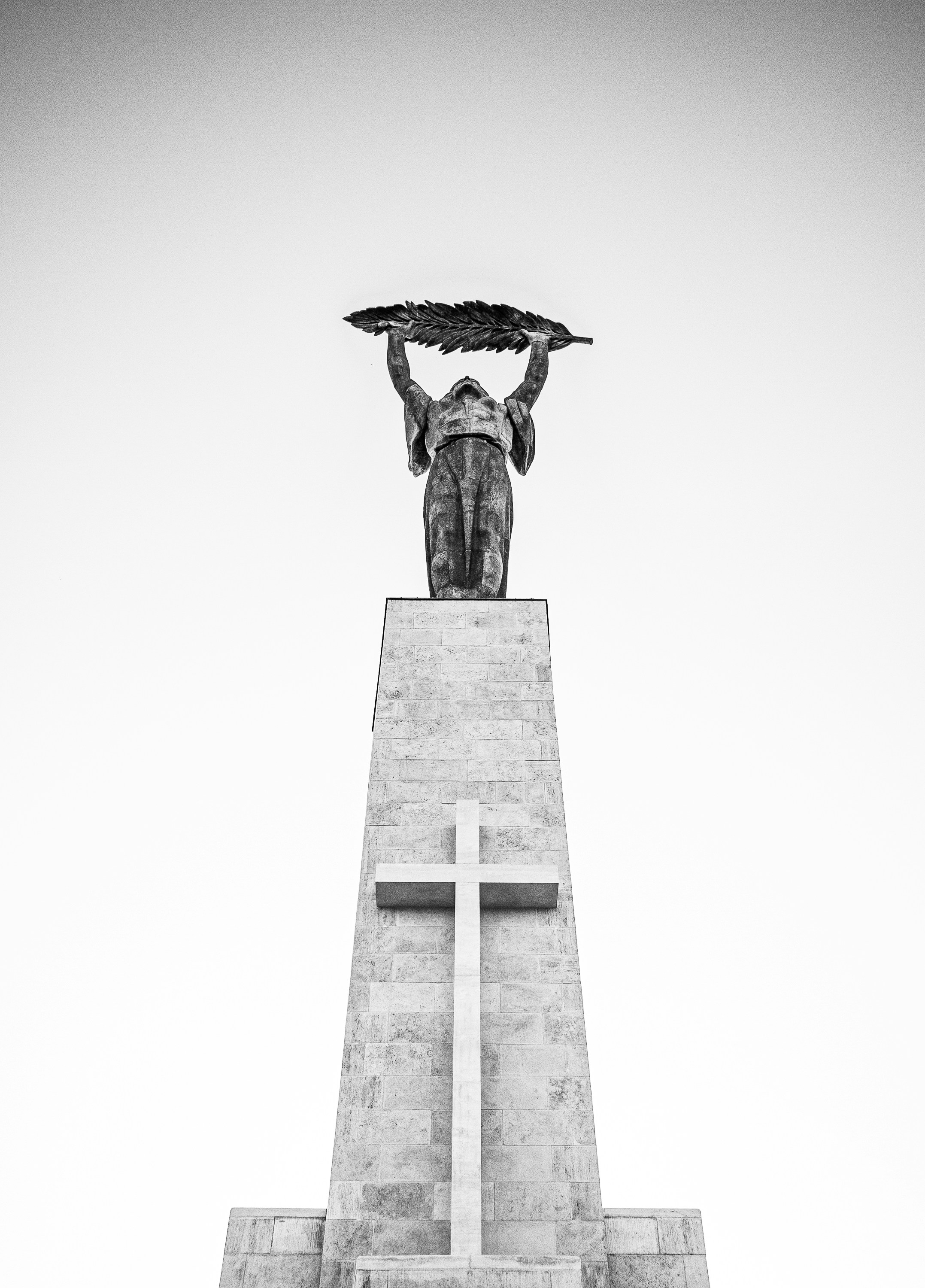 Statue of liberty holding wreath above monument