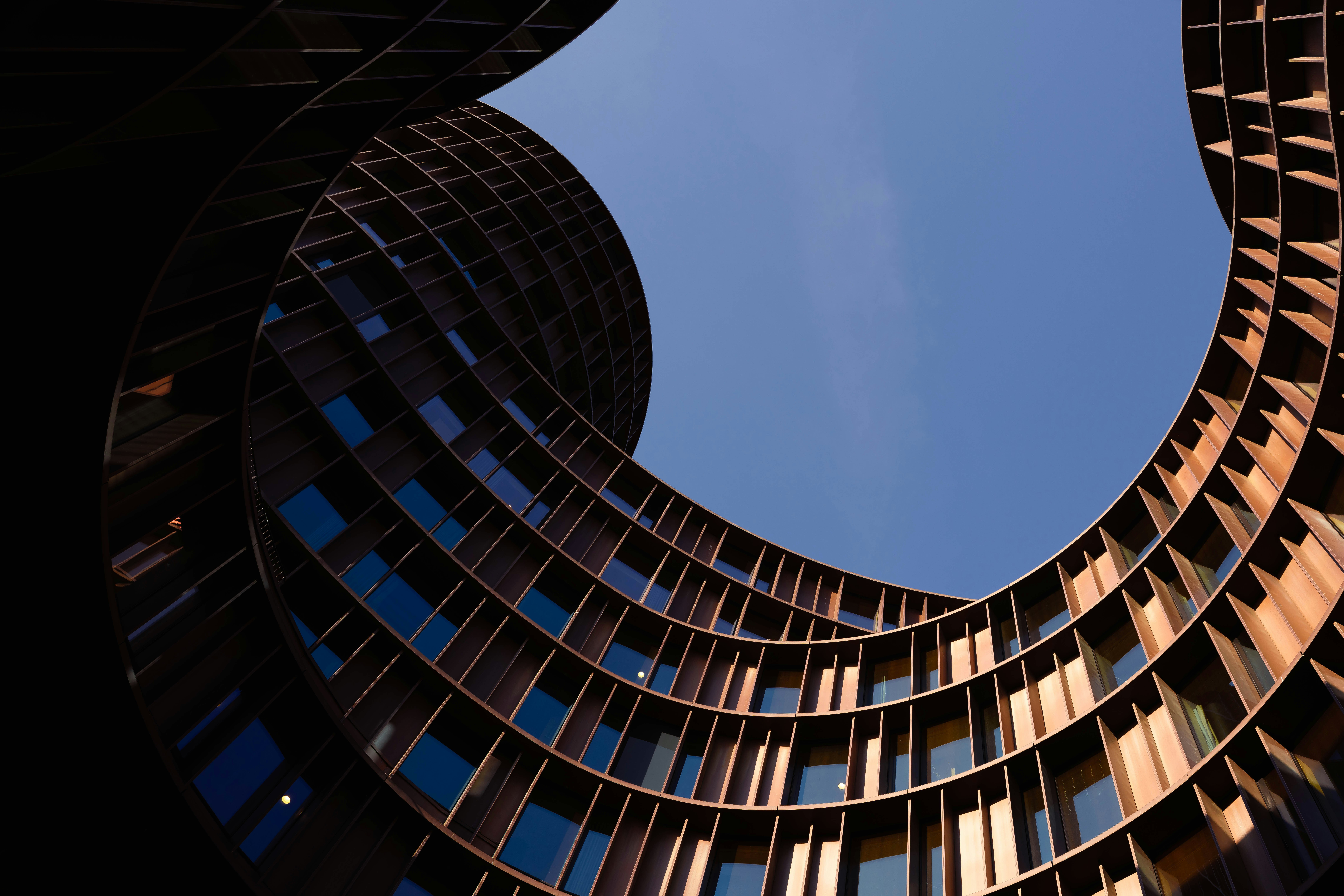 Edificio moderno con fachada de madera curva contra cielo azul