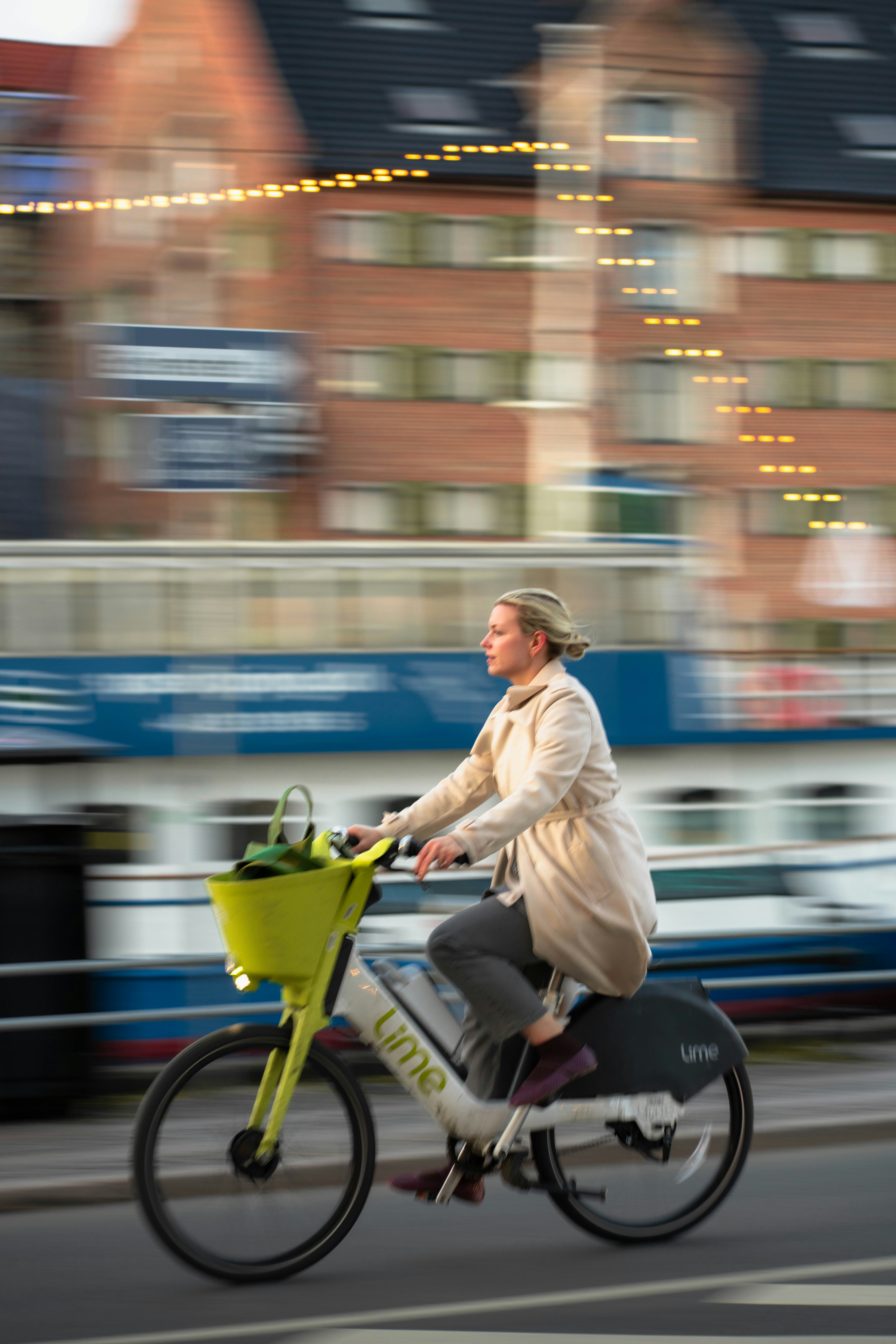 Mujer montando en una bici lime con desenfoque de movimiento.