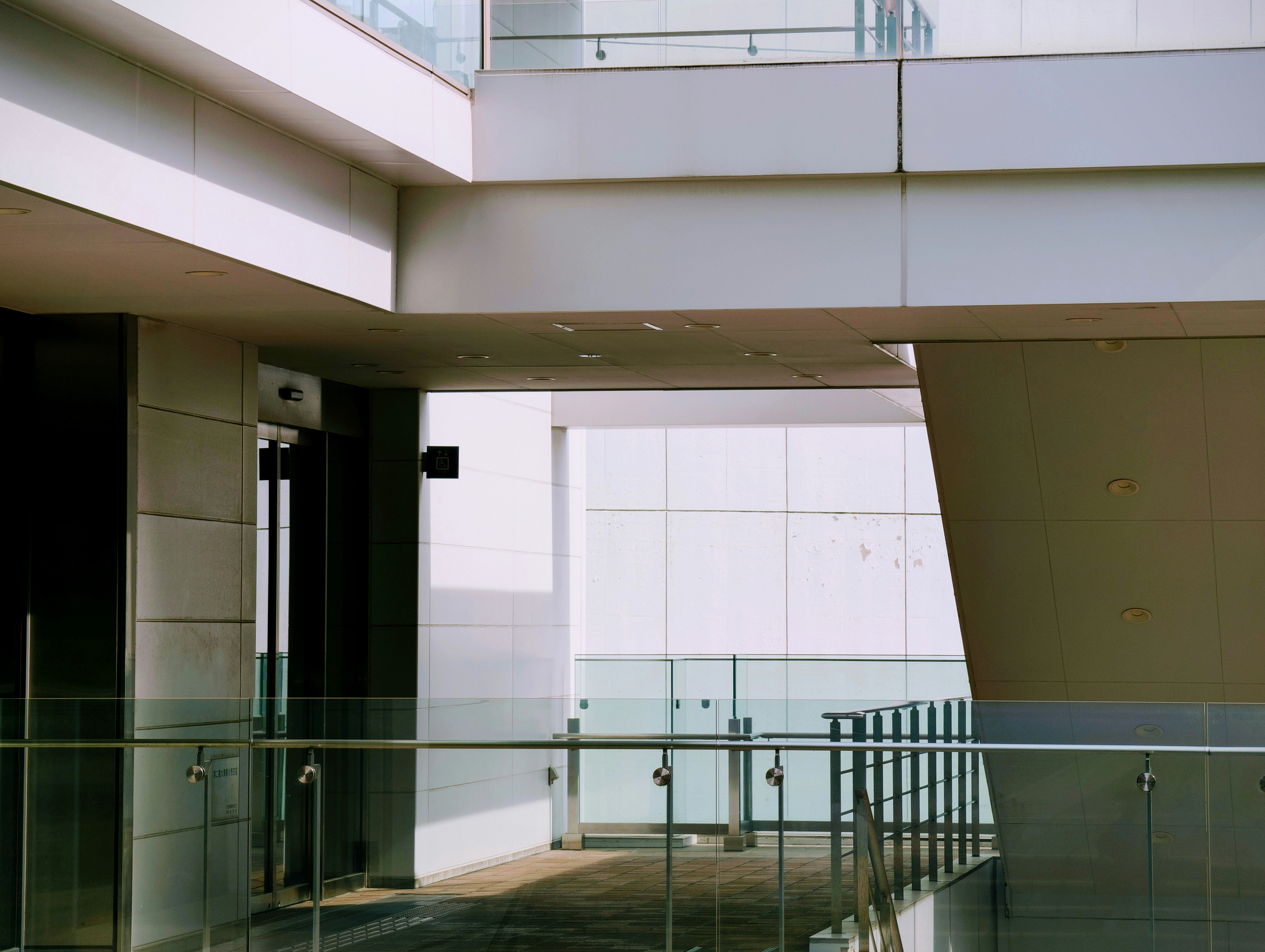 White walls and overhangs of a building stack in layers, lit by bright daylight with soft shadows.