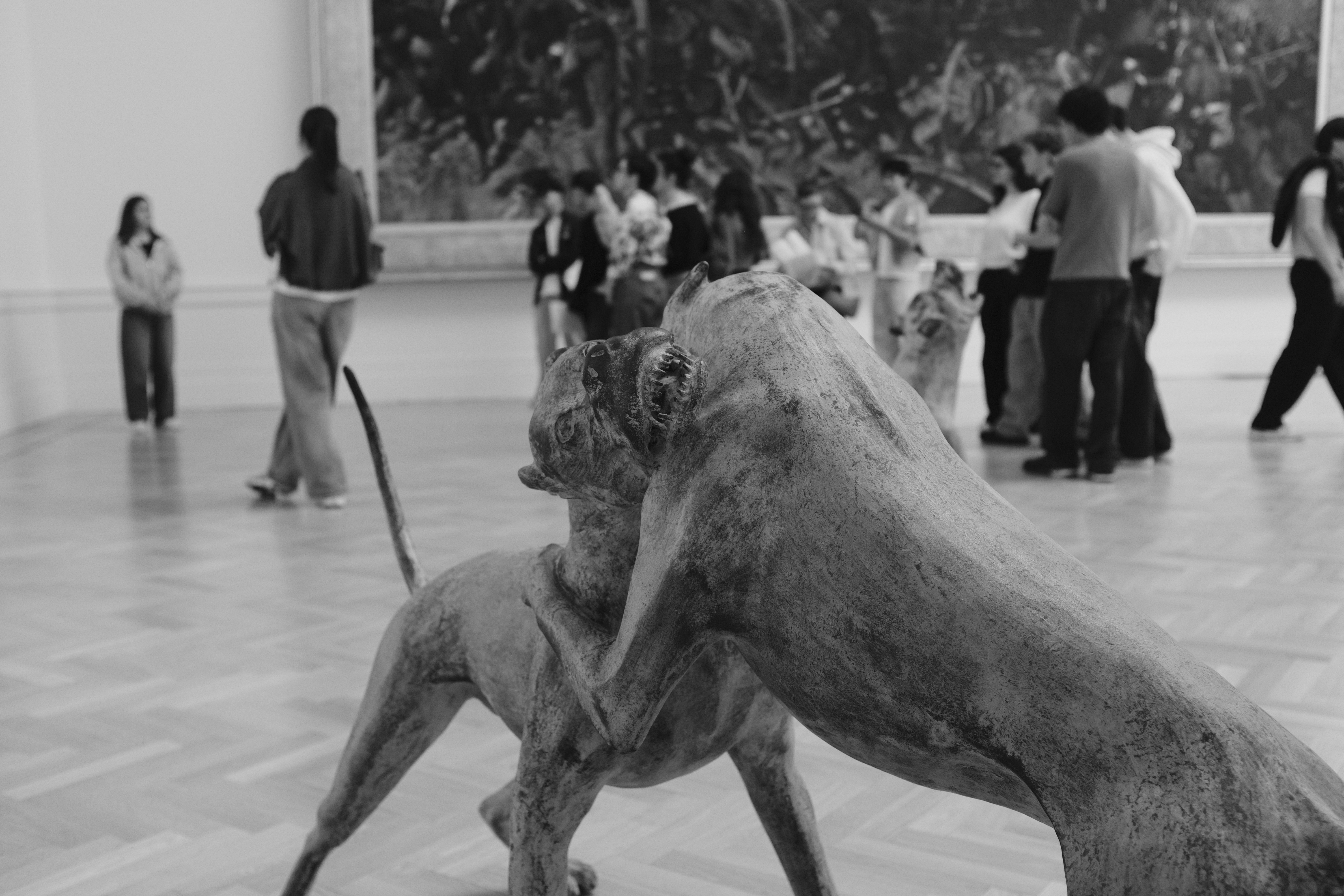 Sculpture of two animals in a museum with visitors