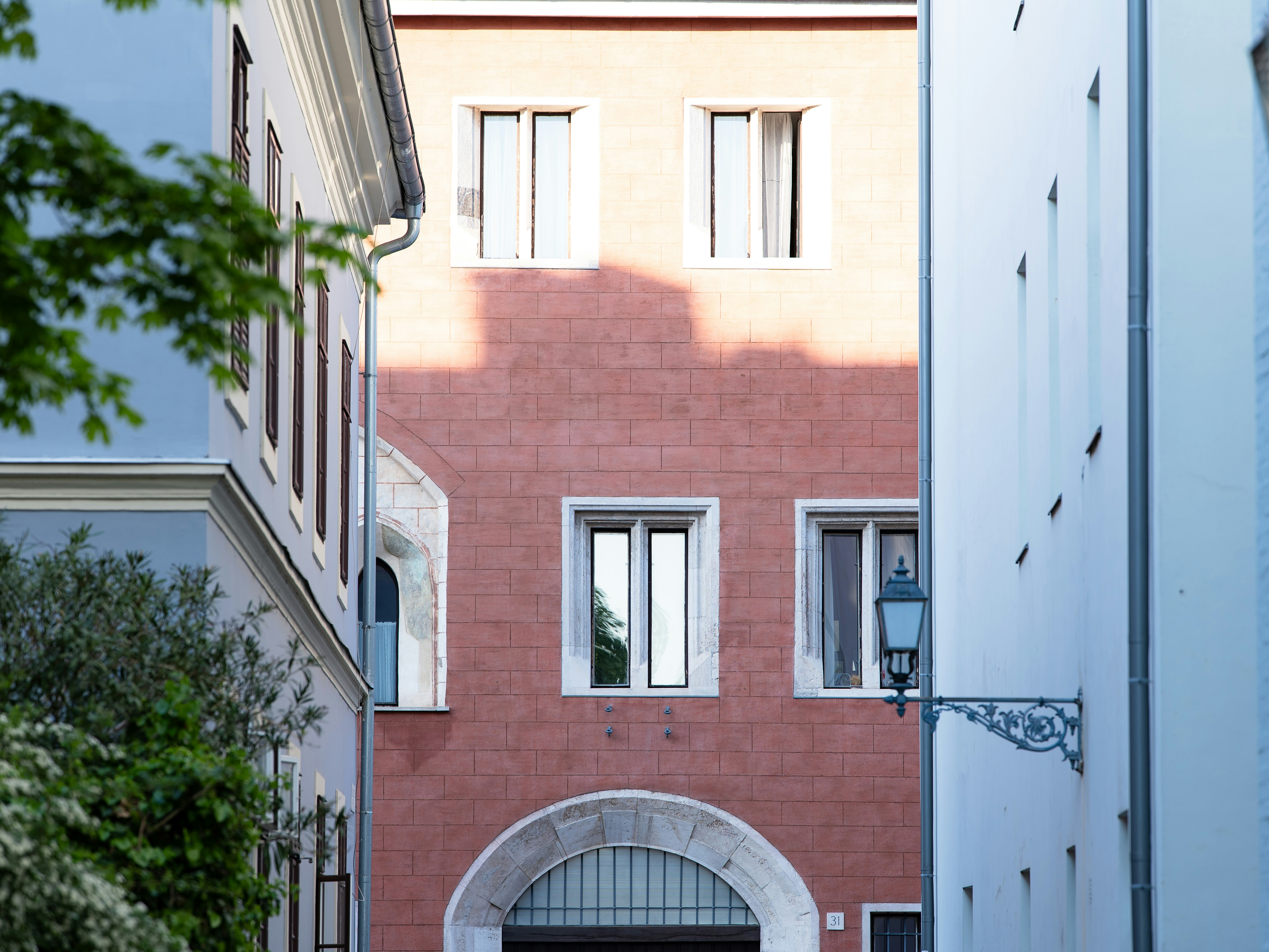 Buildings with arched entrance and windows in alley.
