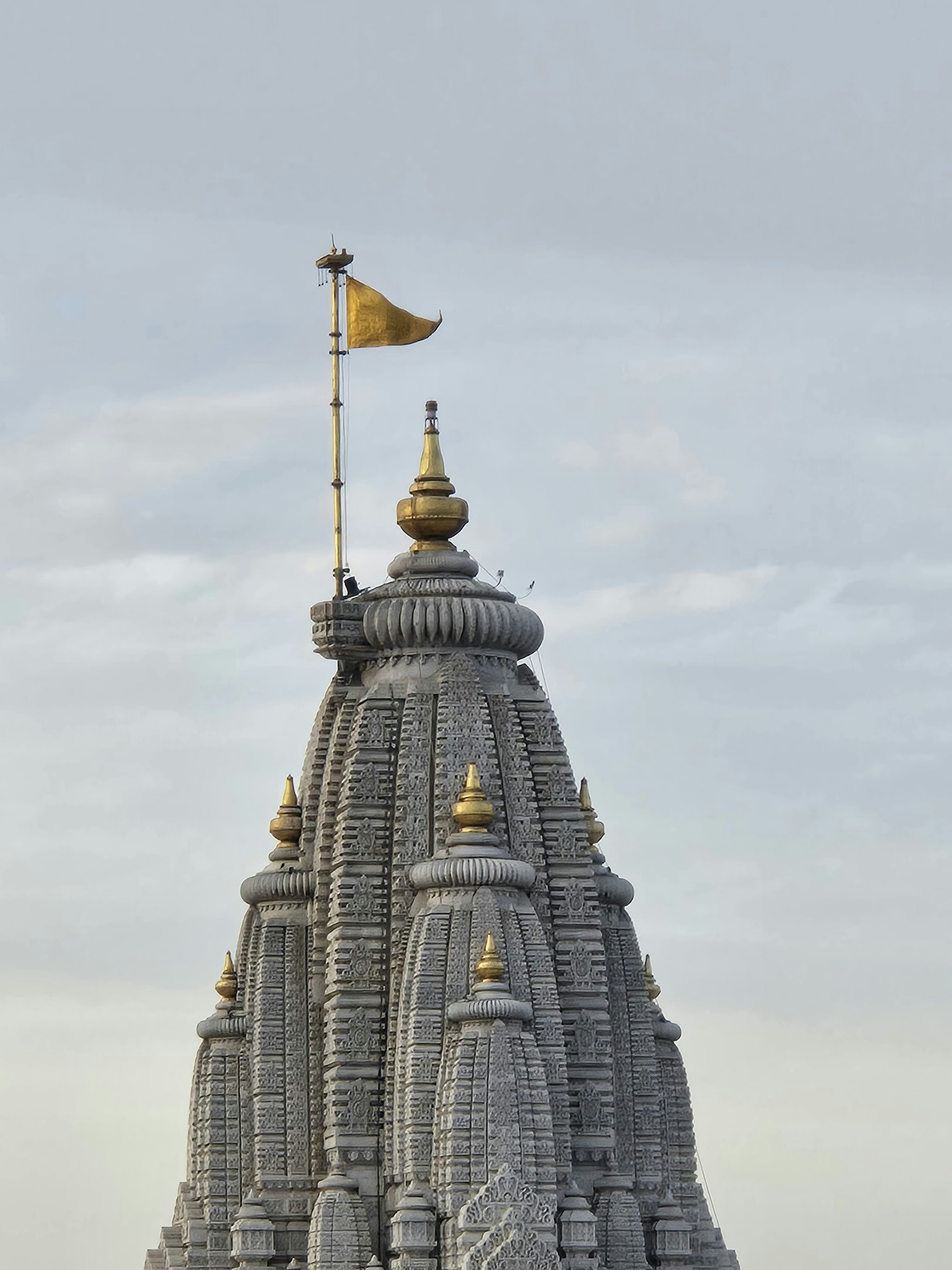 Ornate temple spire with a golden flag