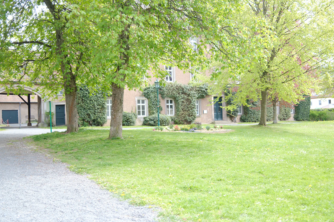 Country house surrounded by green trees and lawn in spring