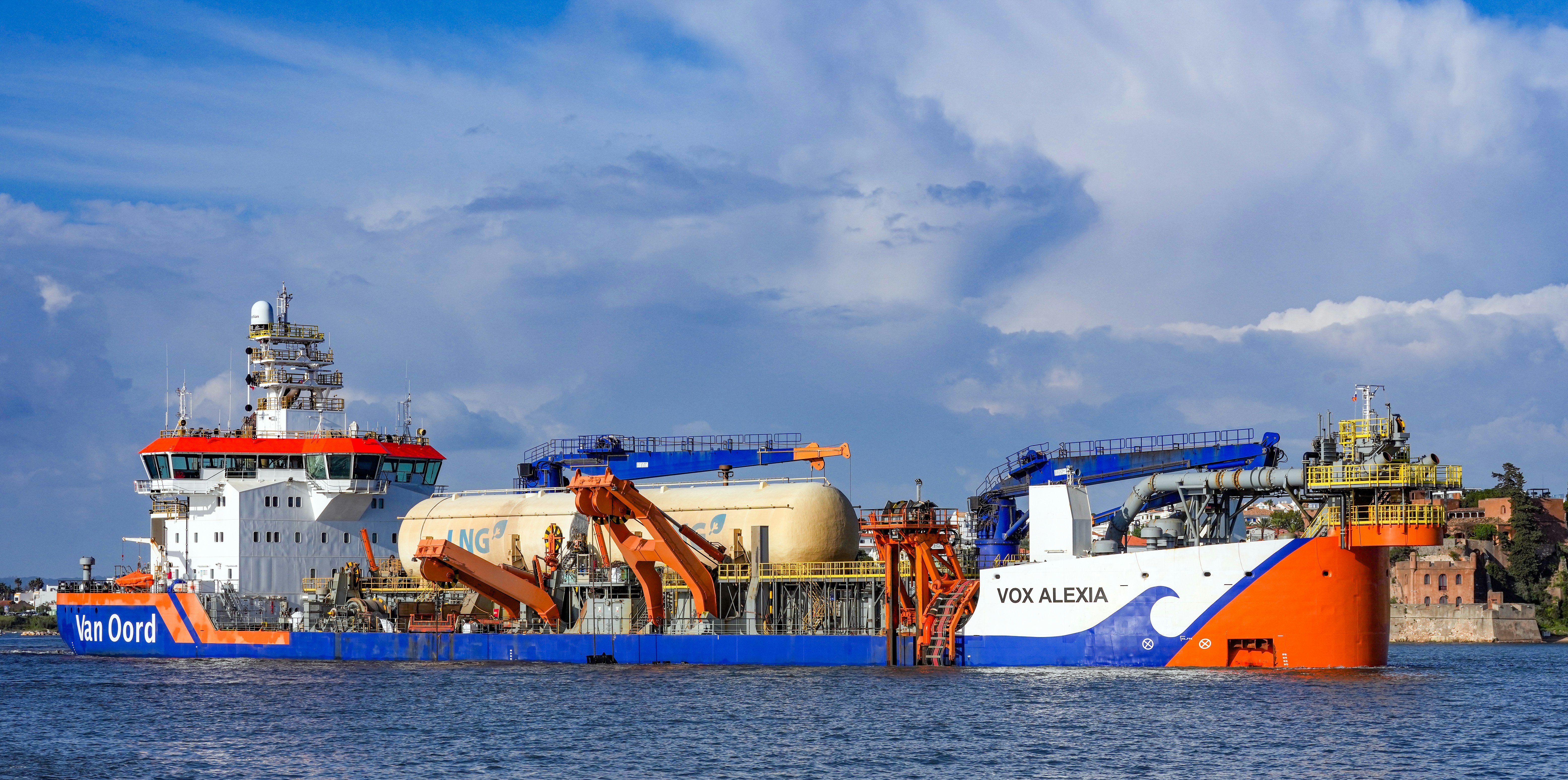 A large industrial ship with cranes on the water.