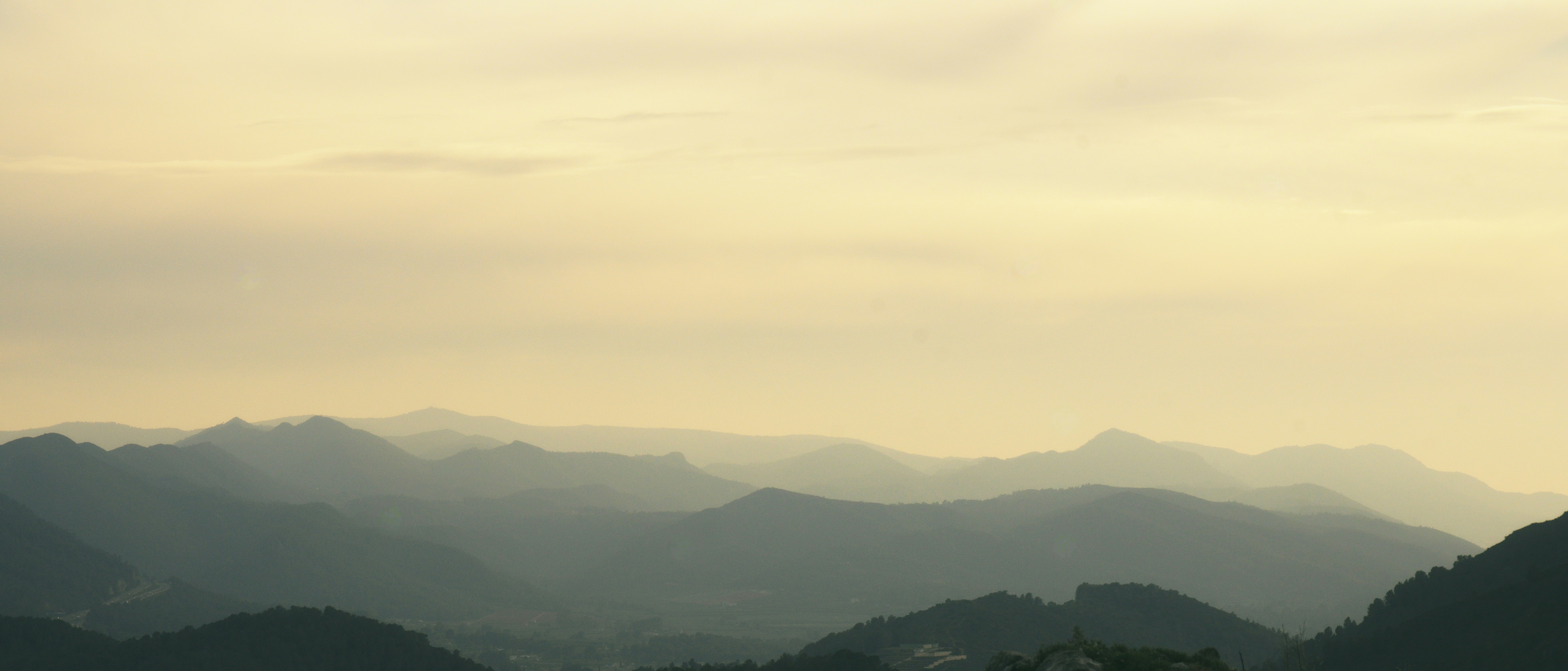 Layered mountain ranges under a hazy sky
