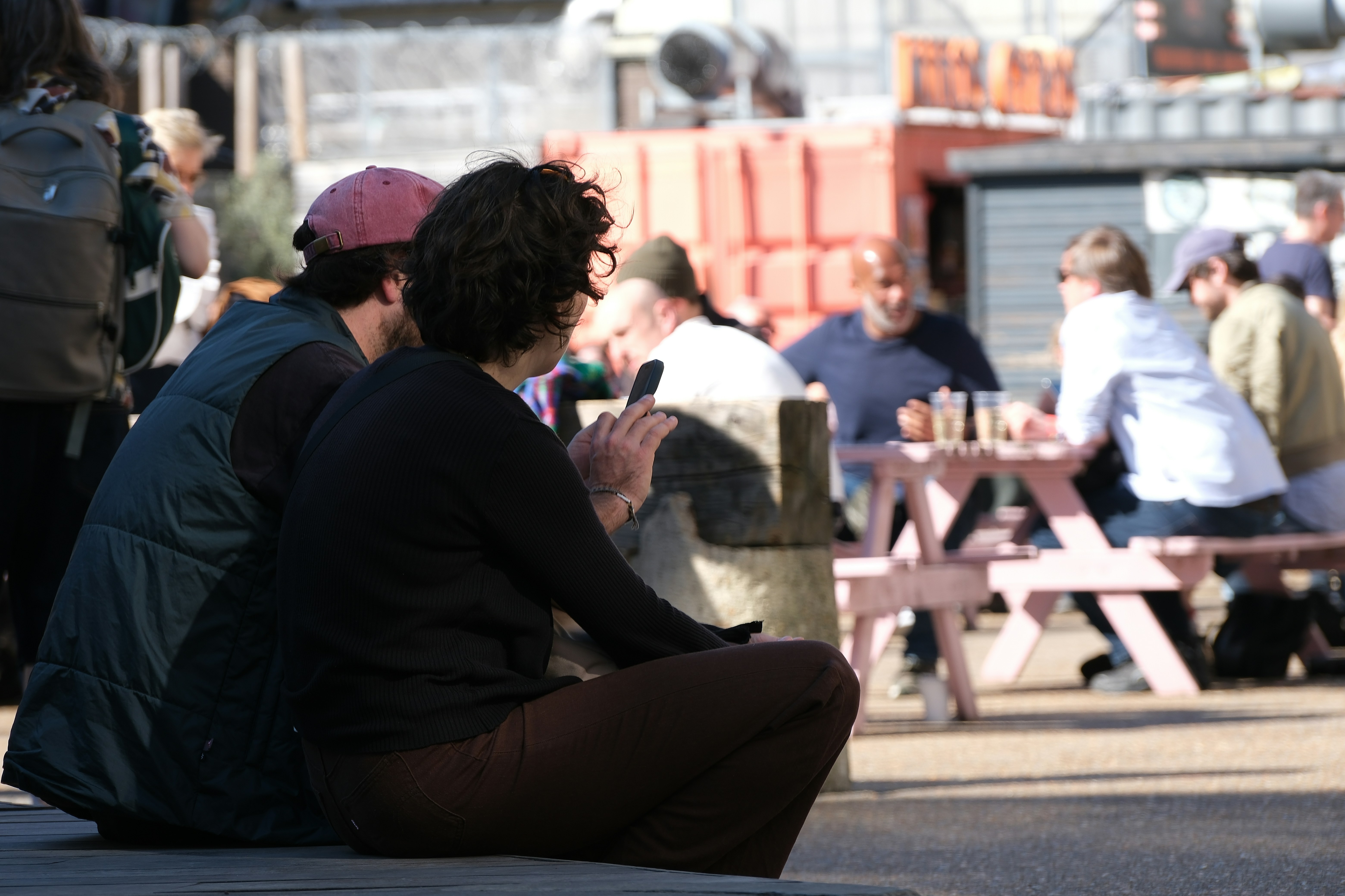 People sitting at picnic tables outdoors