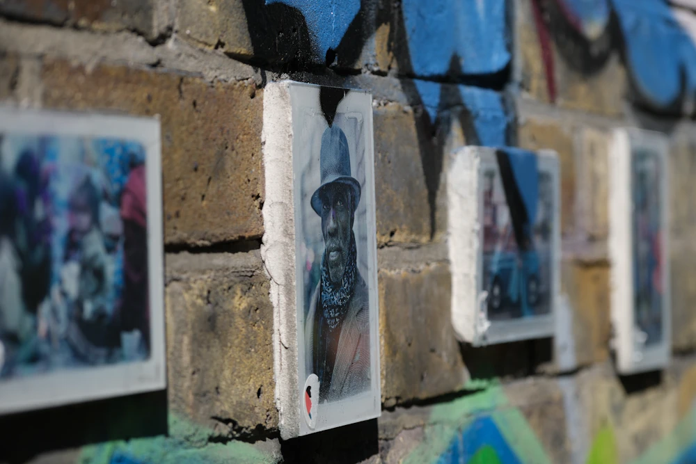 Small street-art portraits on a brick wall in Spitalfields