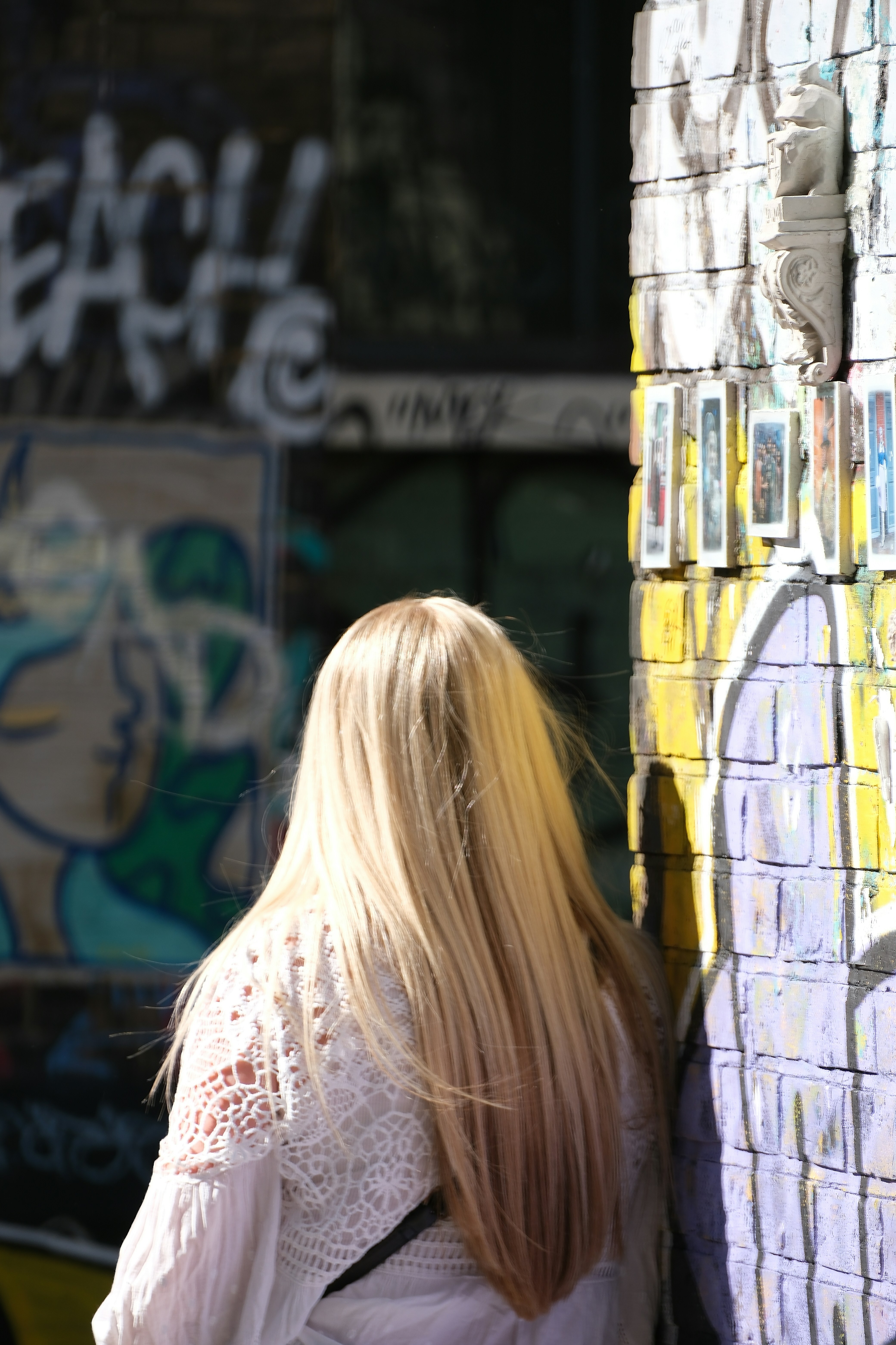 Femme aux cheveux blonds près d’un mur de graffitis