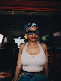 Woman wearing sunglasses and headscarf inside car