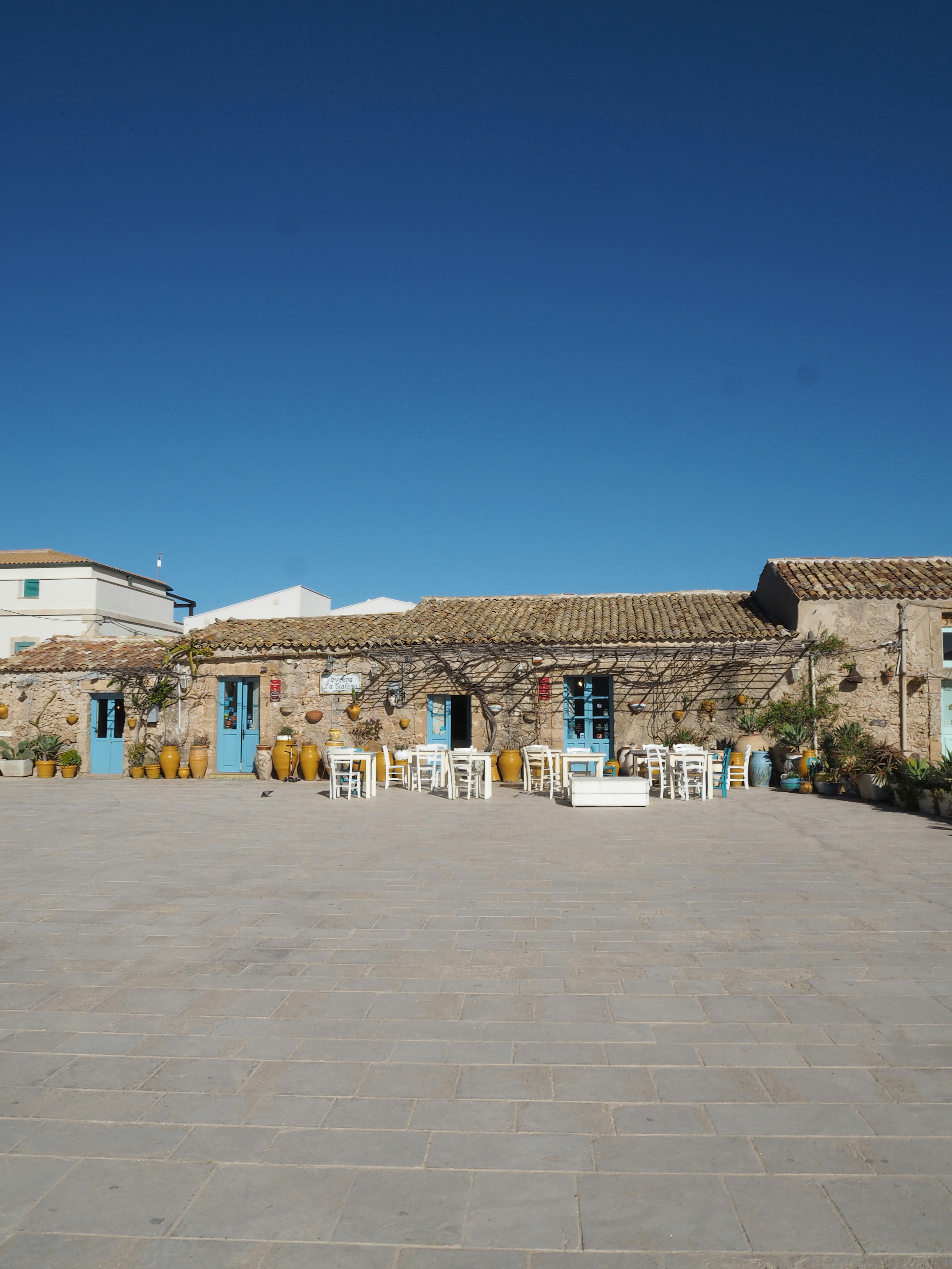 Stone building with blue doors and outdoor seating