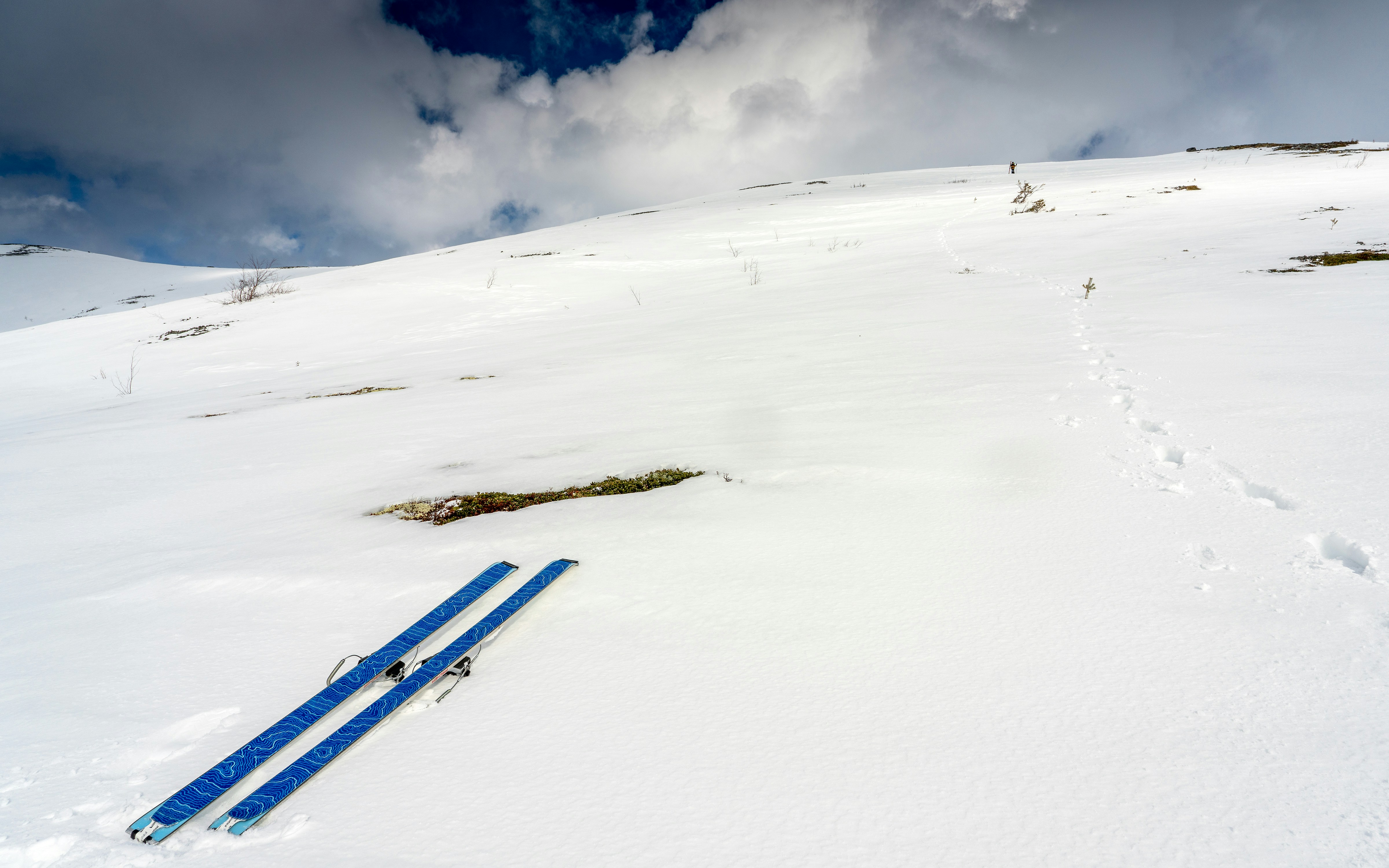 Ski tergeletak di lereng gunung bersalju