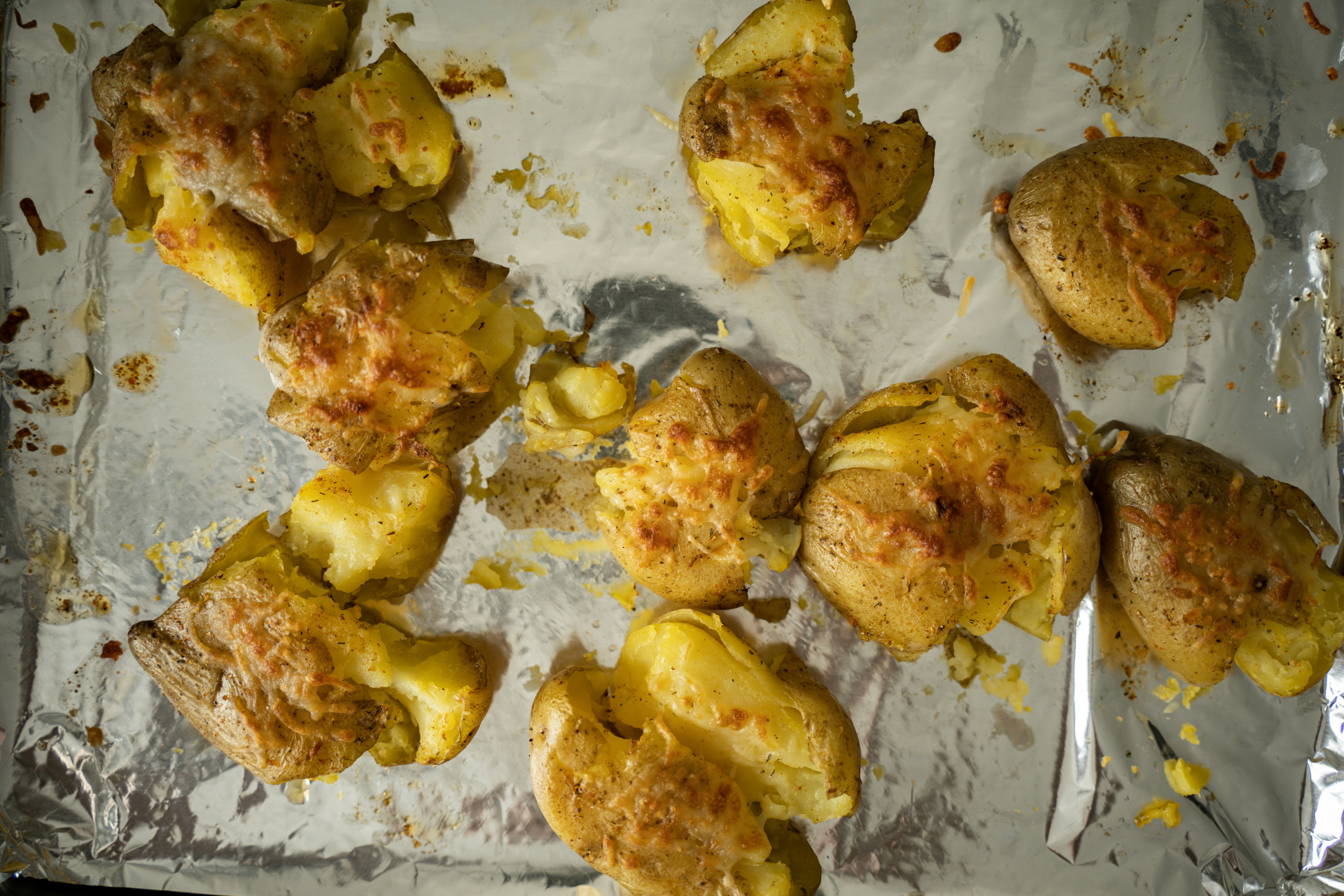 crispy smashed potatoes on a baking sheet garnished with herbs - simple vegan potato recipes