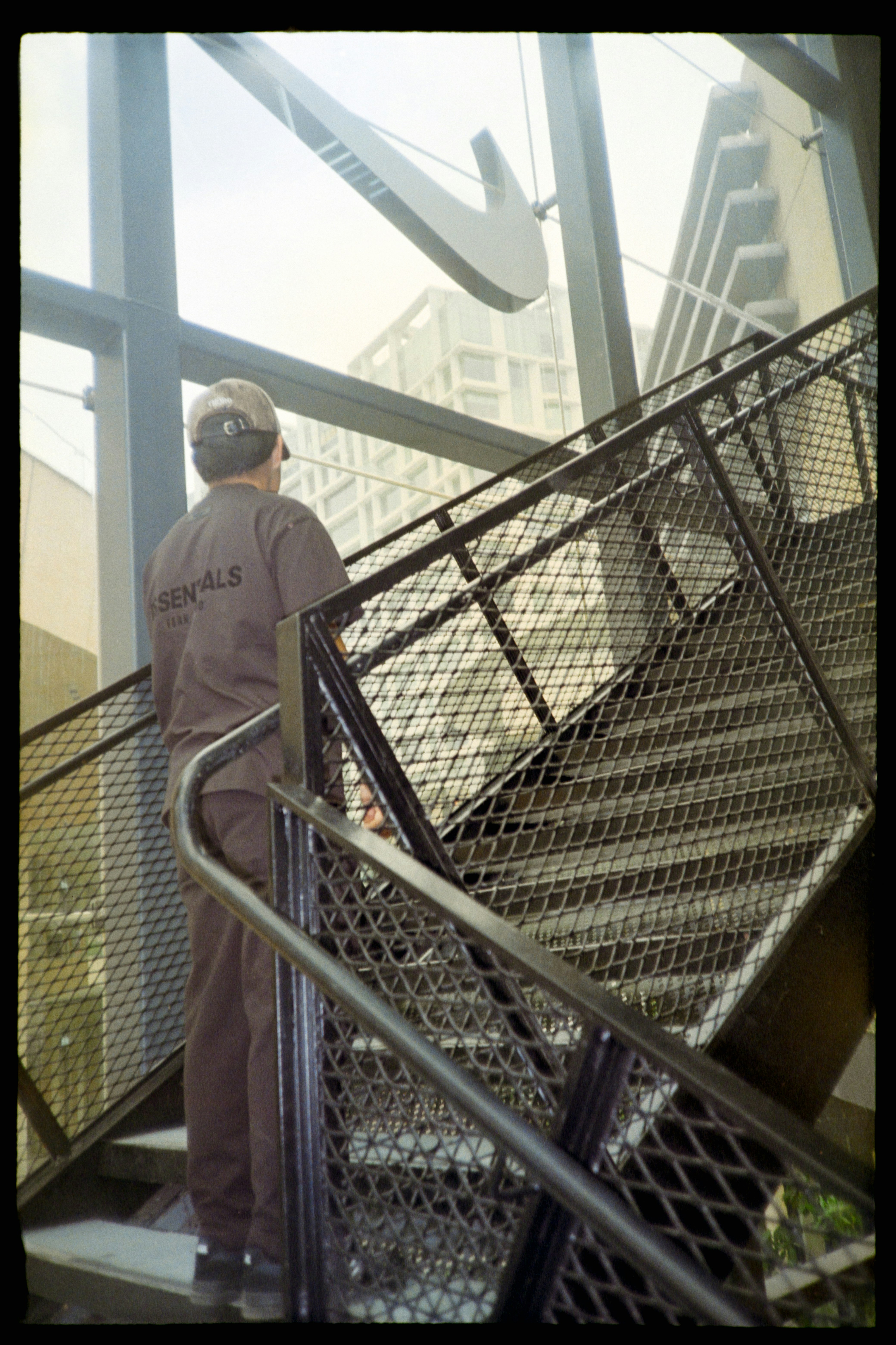 Man in a cap on a metal staircase looking up