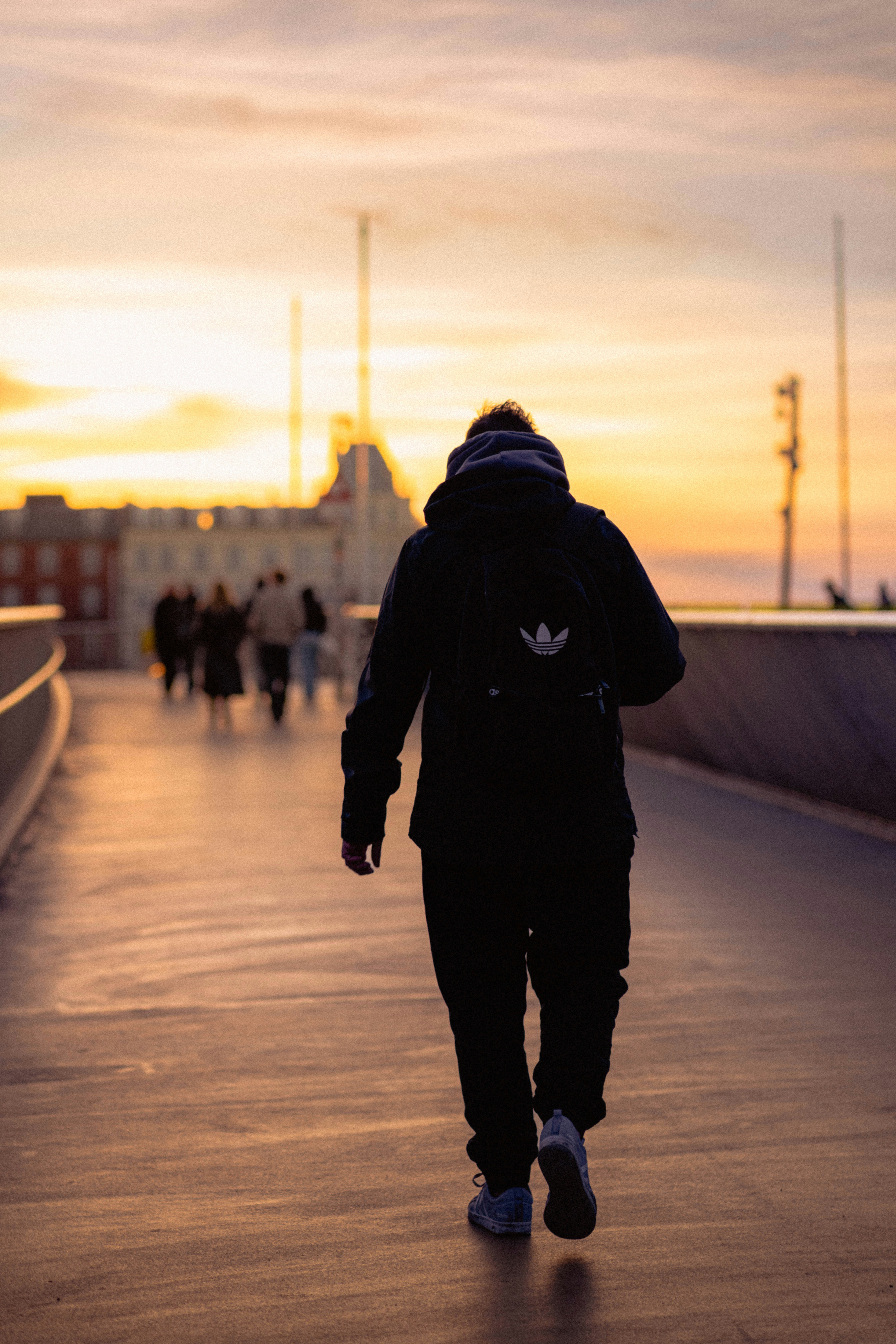 Persona caminando por un puente al atardecer