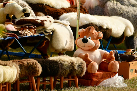 A plush teddy bear sits on a small chair.