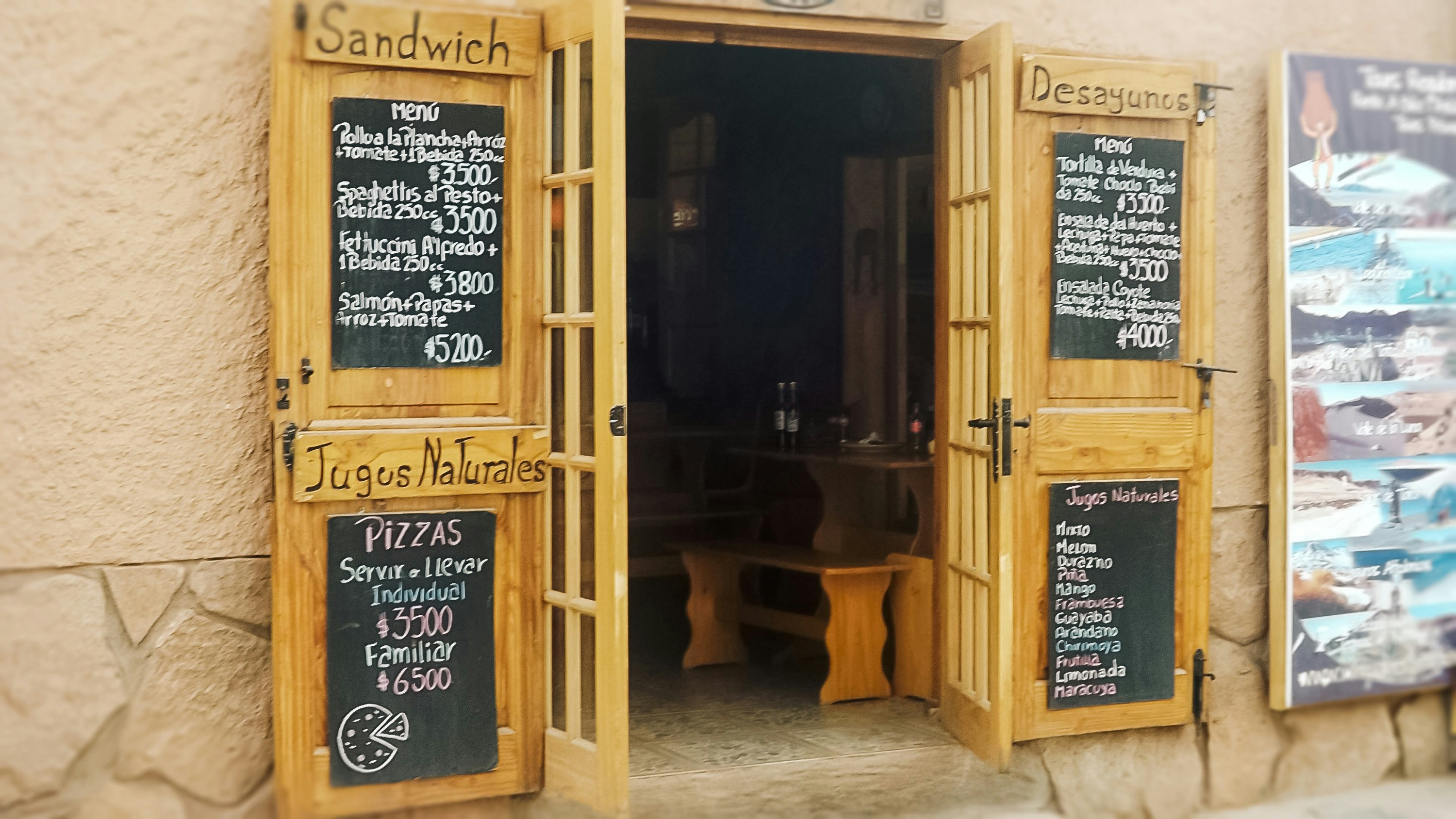 Portas de madeira de um restaurante com quadros-negros.