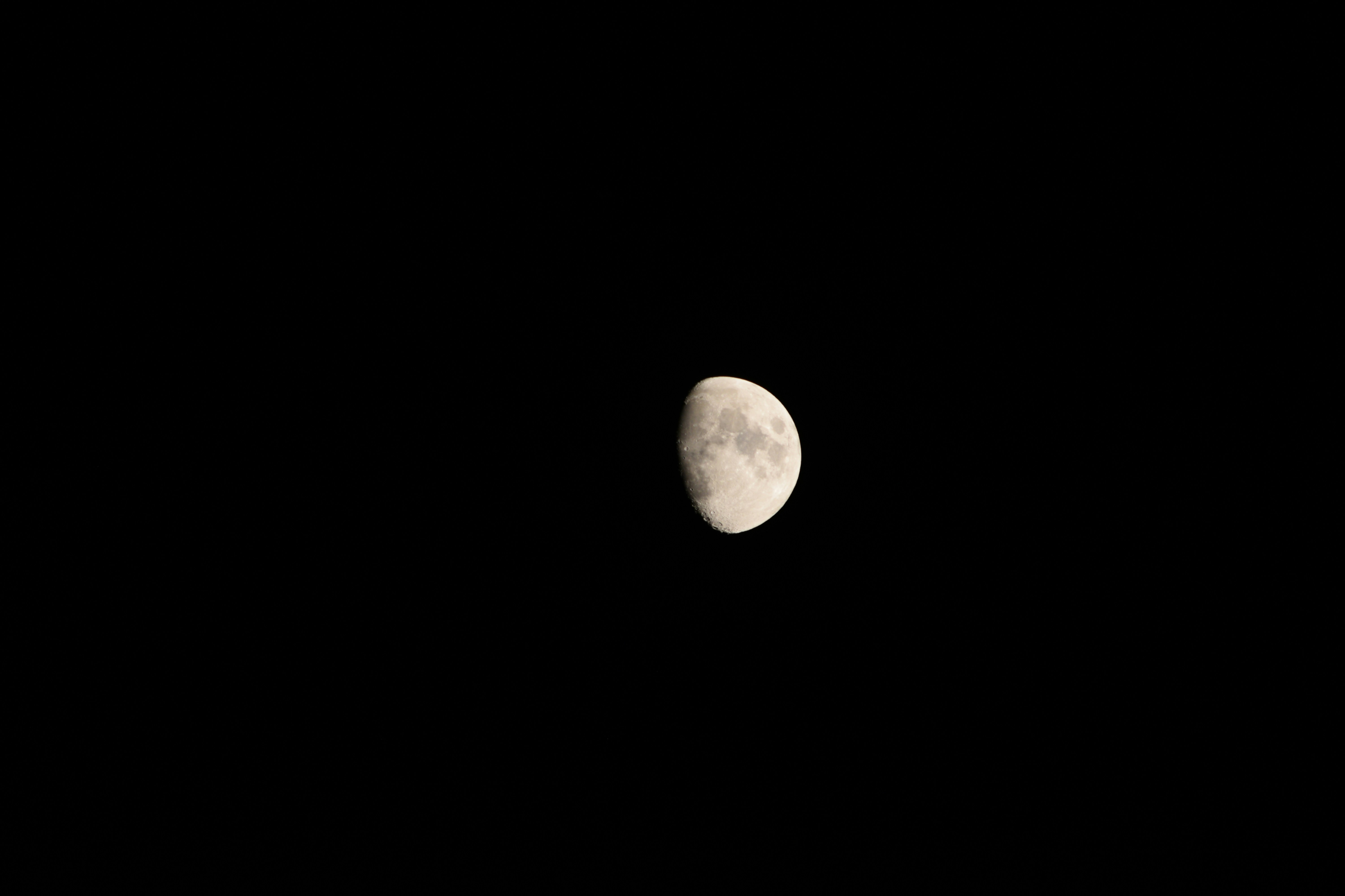 Una luna crescente brilla nel cielo notturno scuro.