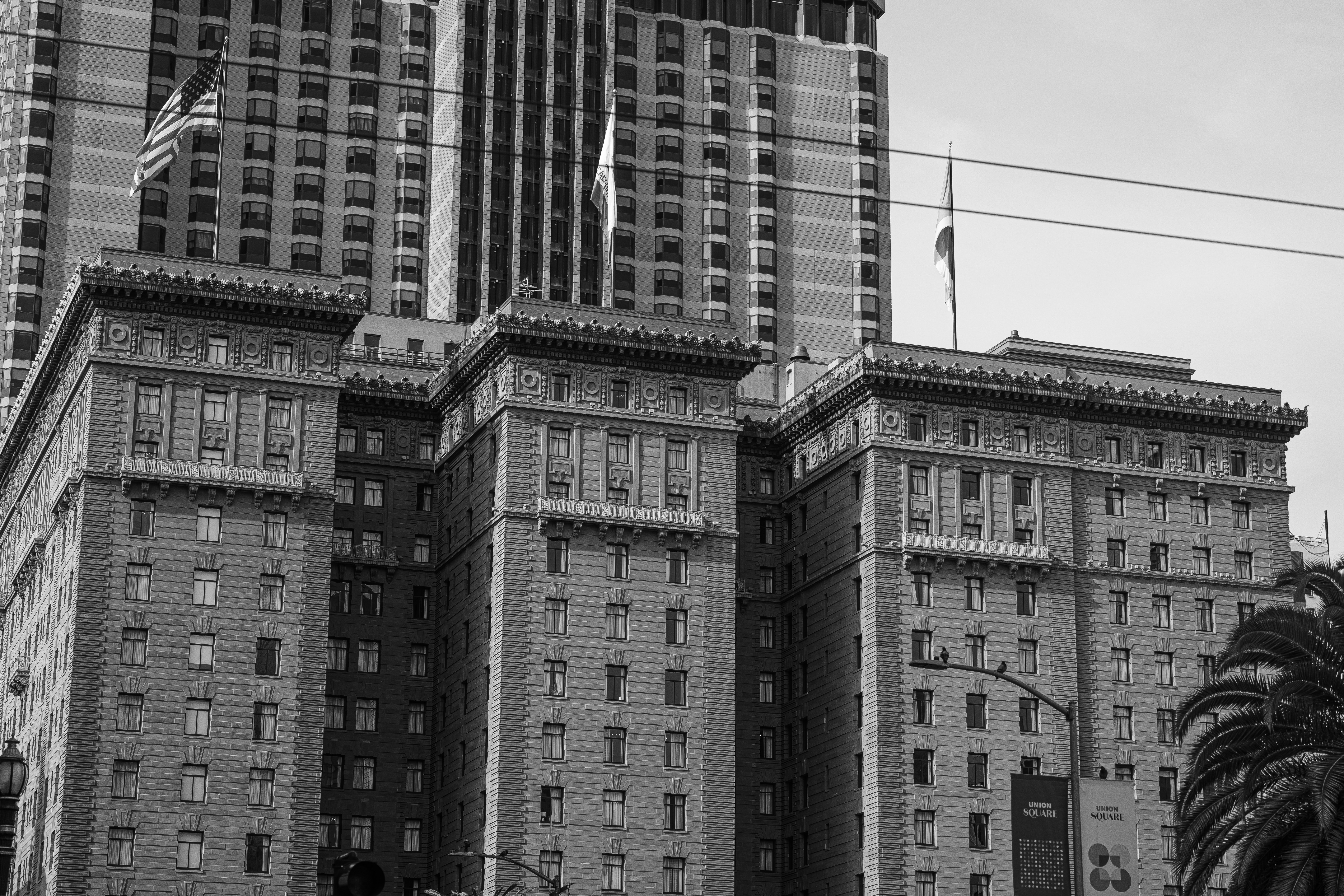 Tall buildings with american flags in black and white.