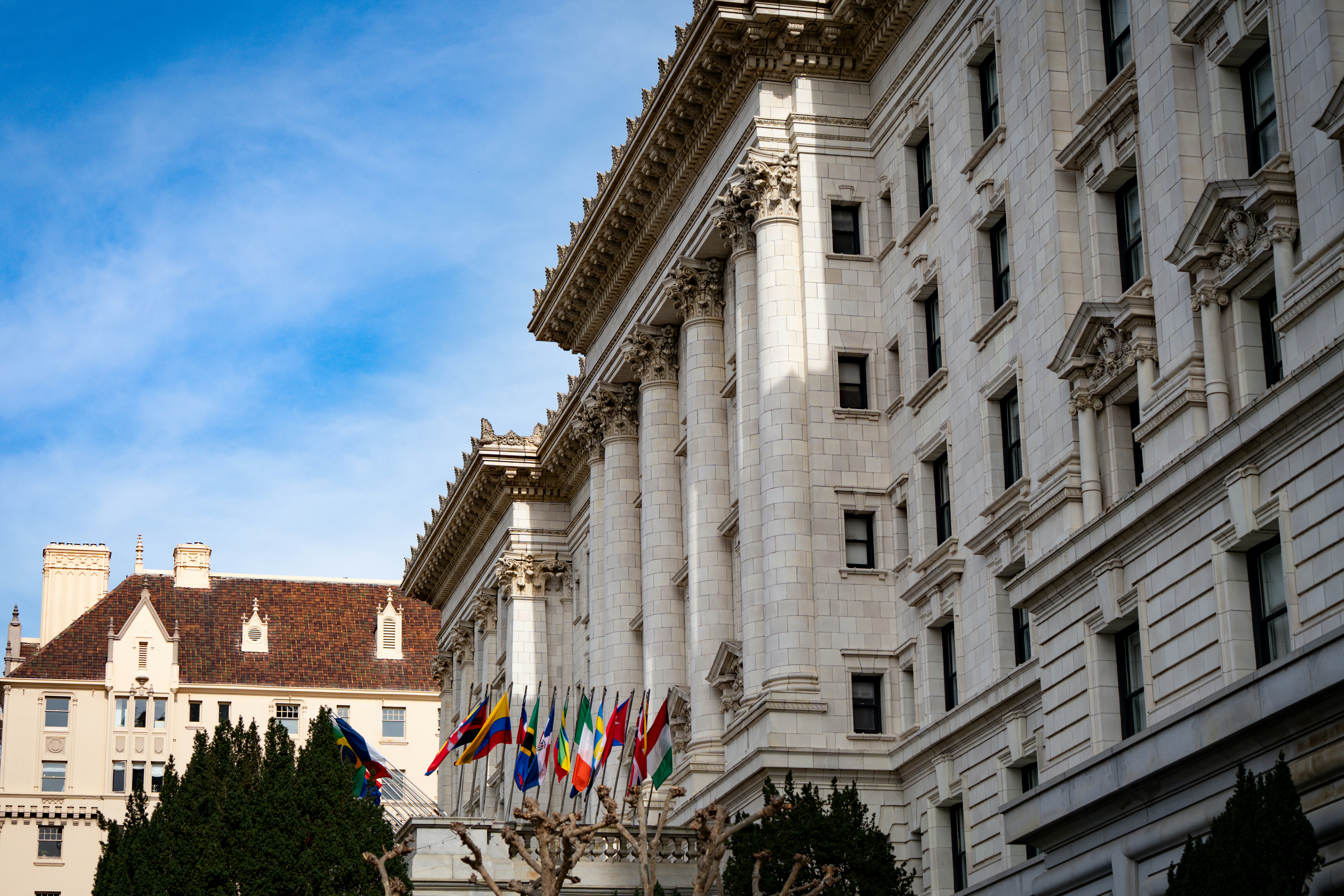 Grand building with columns and flags under blue sky