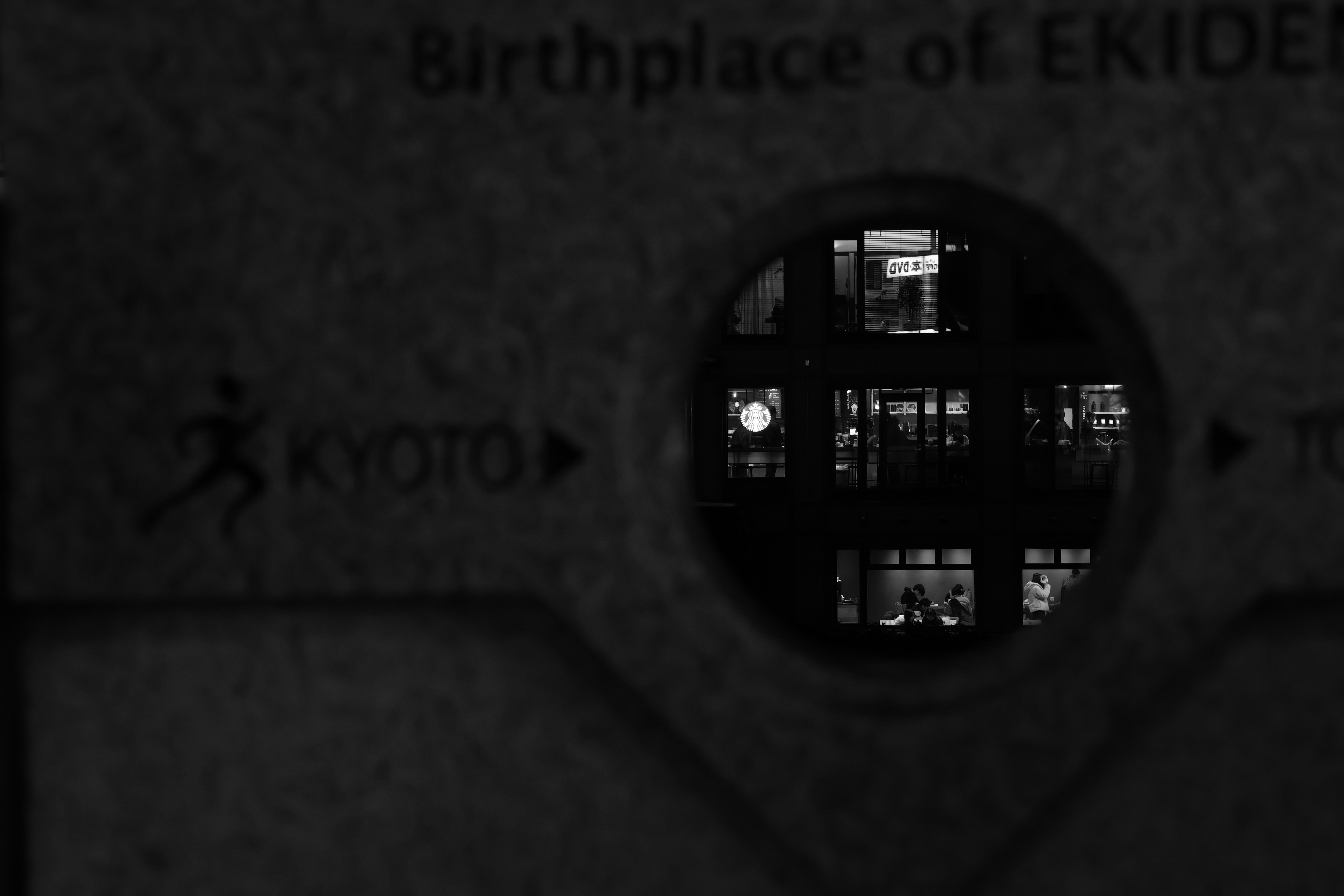Kyoto sign reflected in a circular window at night
