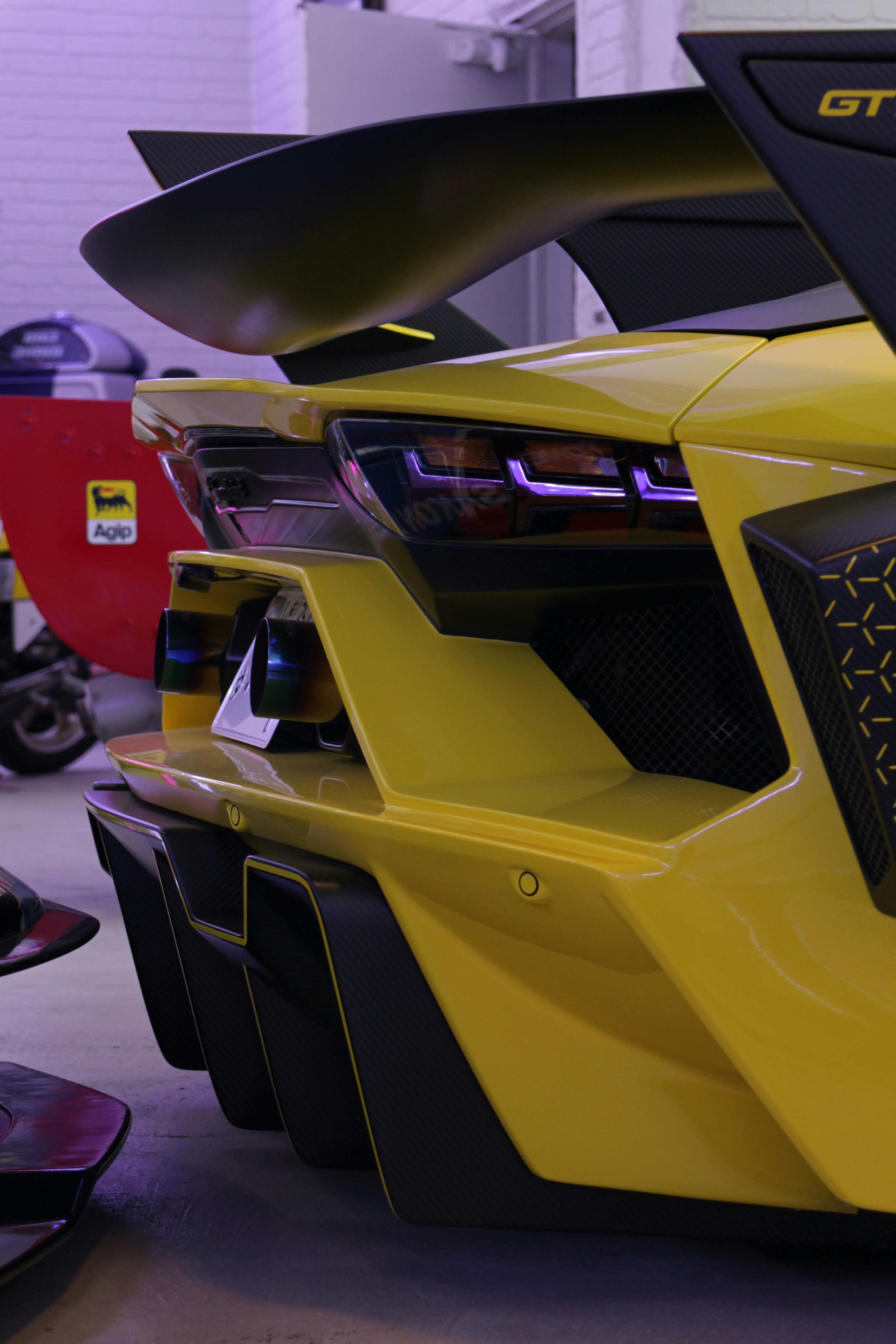 Yellow sports car rear end with aggressive styling