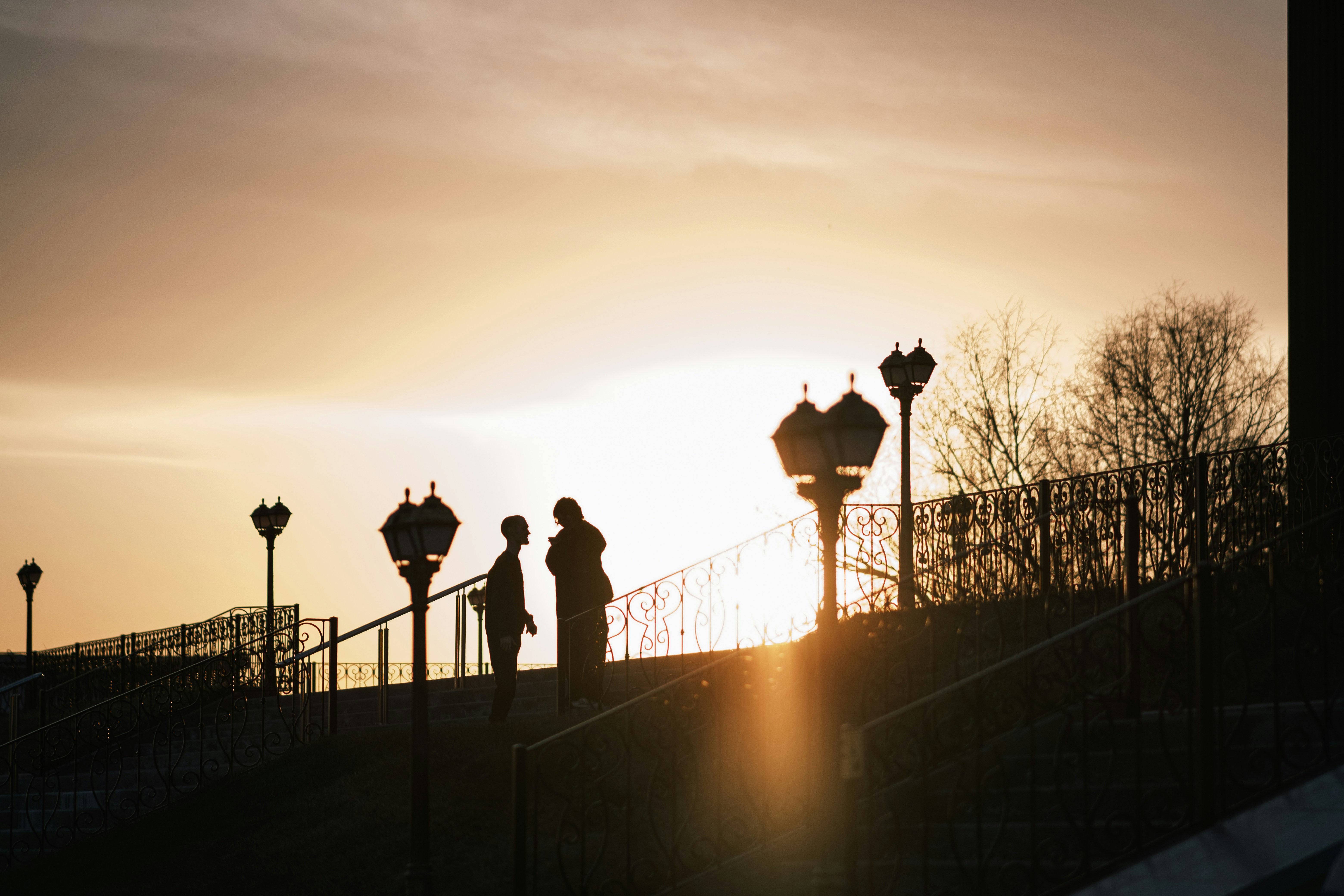 Silhouettes of two people on stairs at sunset