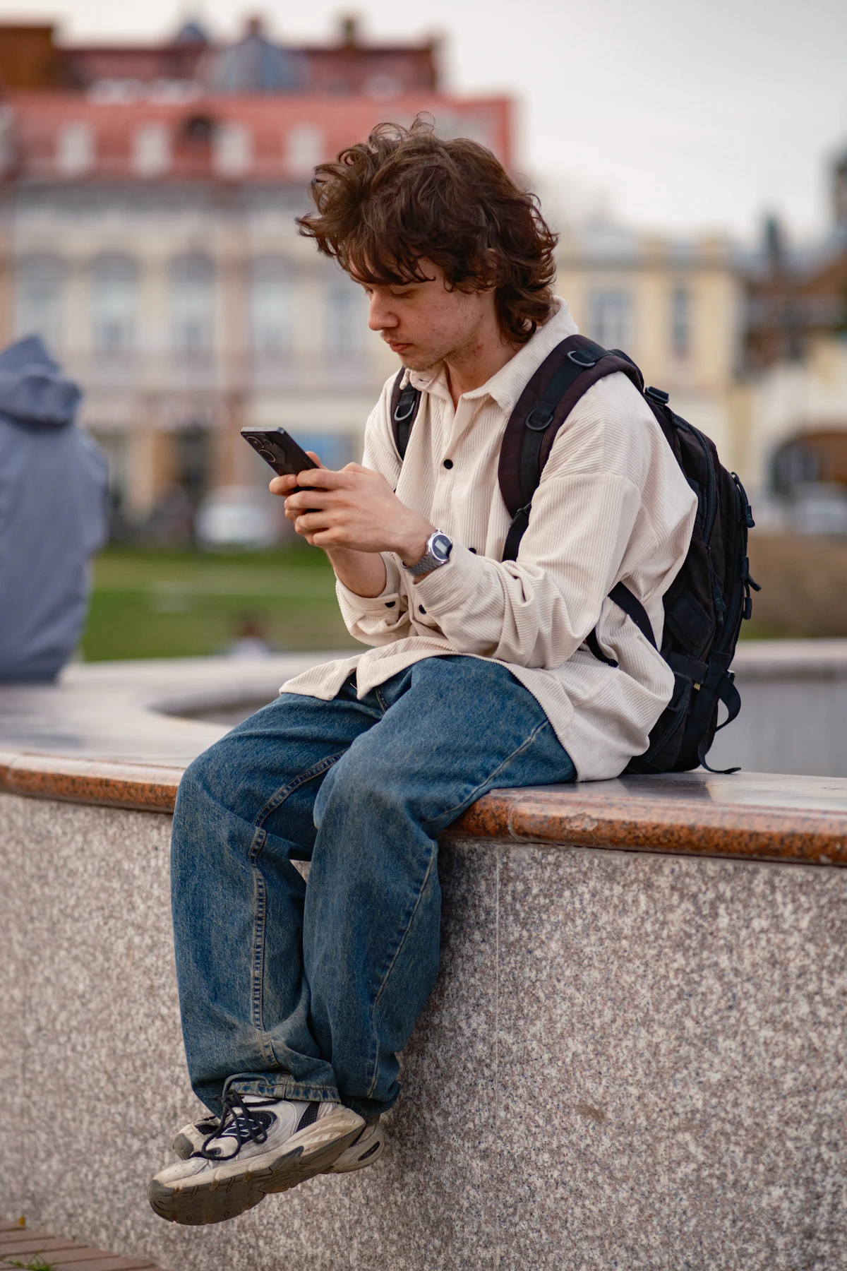 Jeune élève avec son sac à dos qui regarde son smartphone