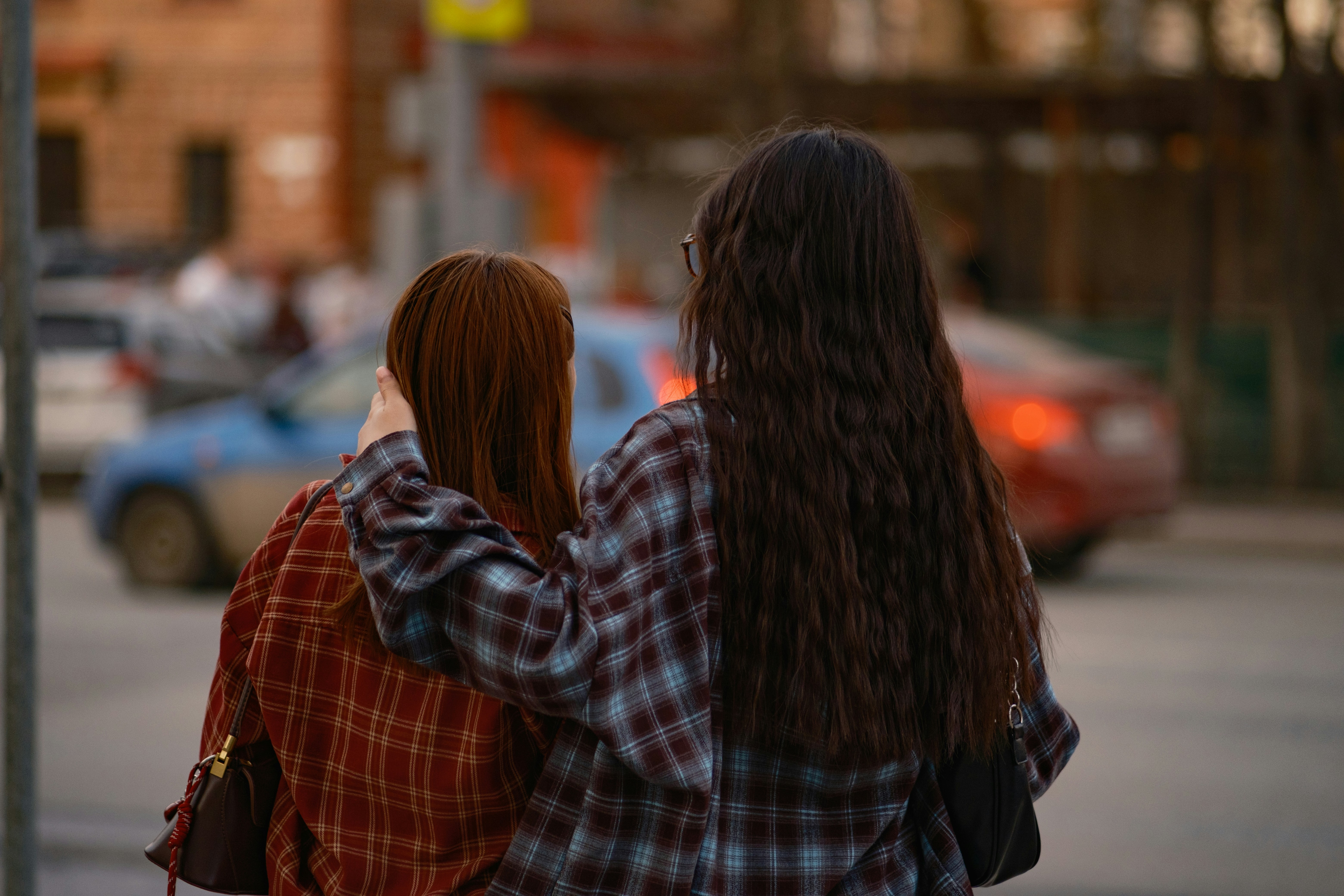 Two women with arms around each other walking
