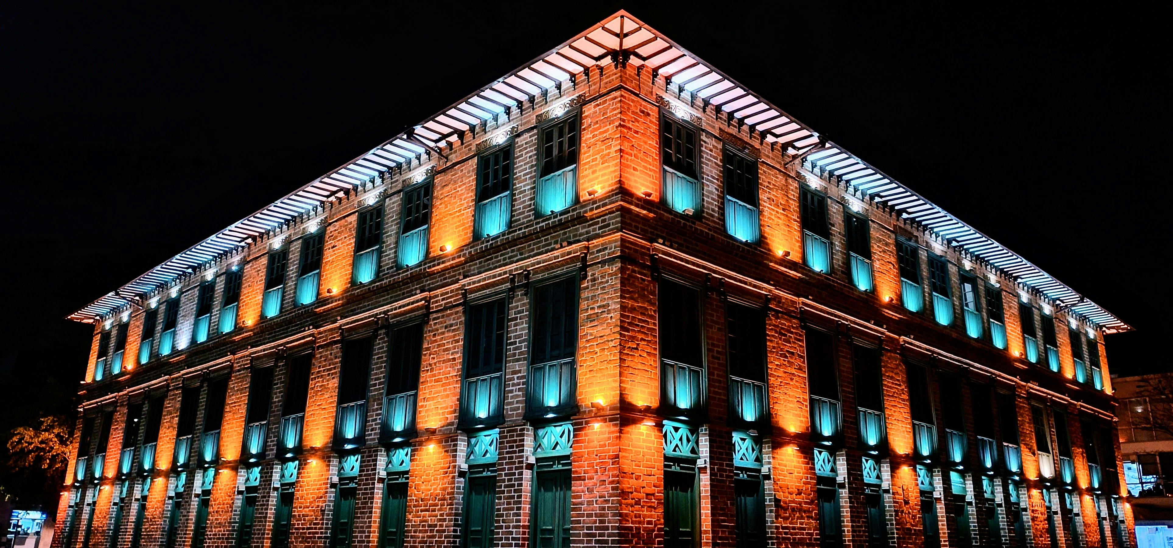 Un bâtiment éclairé de lumières orange et bleue la nuit.