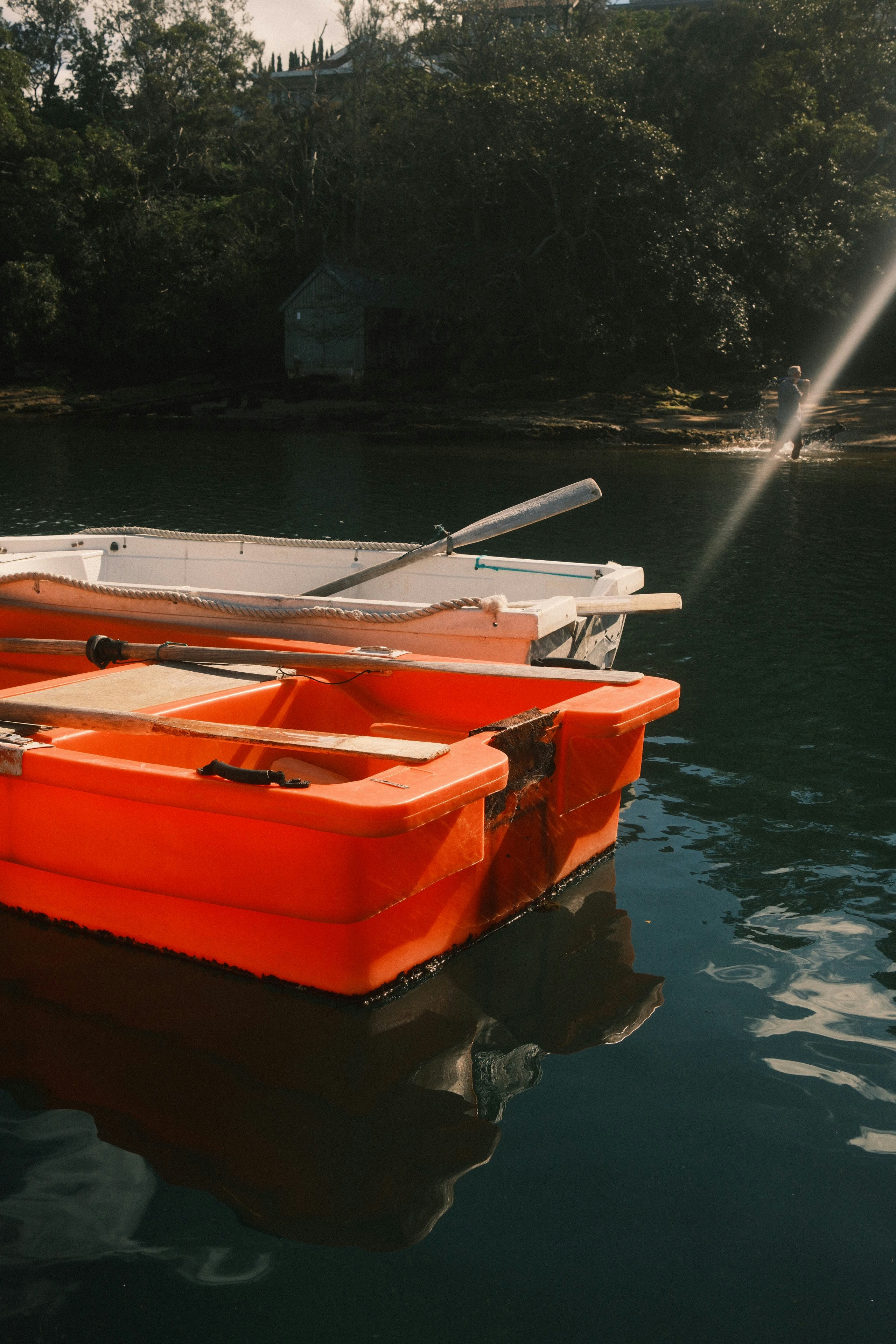 Two small boats float on calm dark water