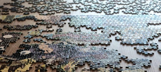 Scattered puzzle pieces on a wooden surface.