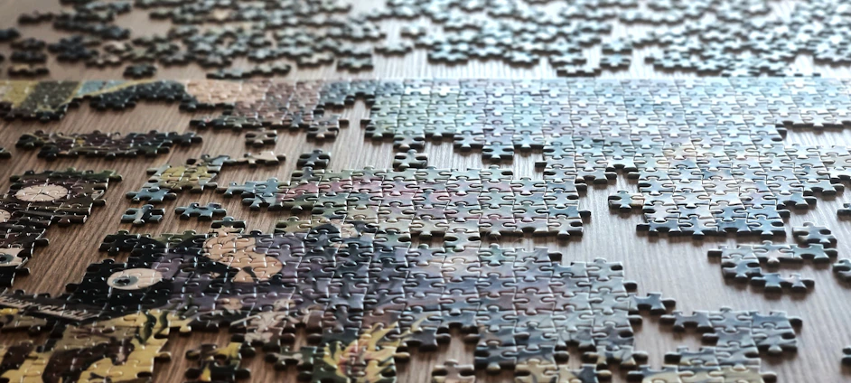 Scattered puzzle pieces on a wooden surface.
