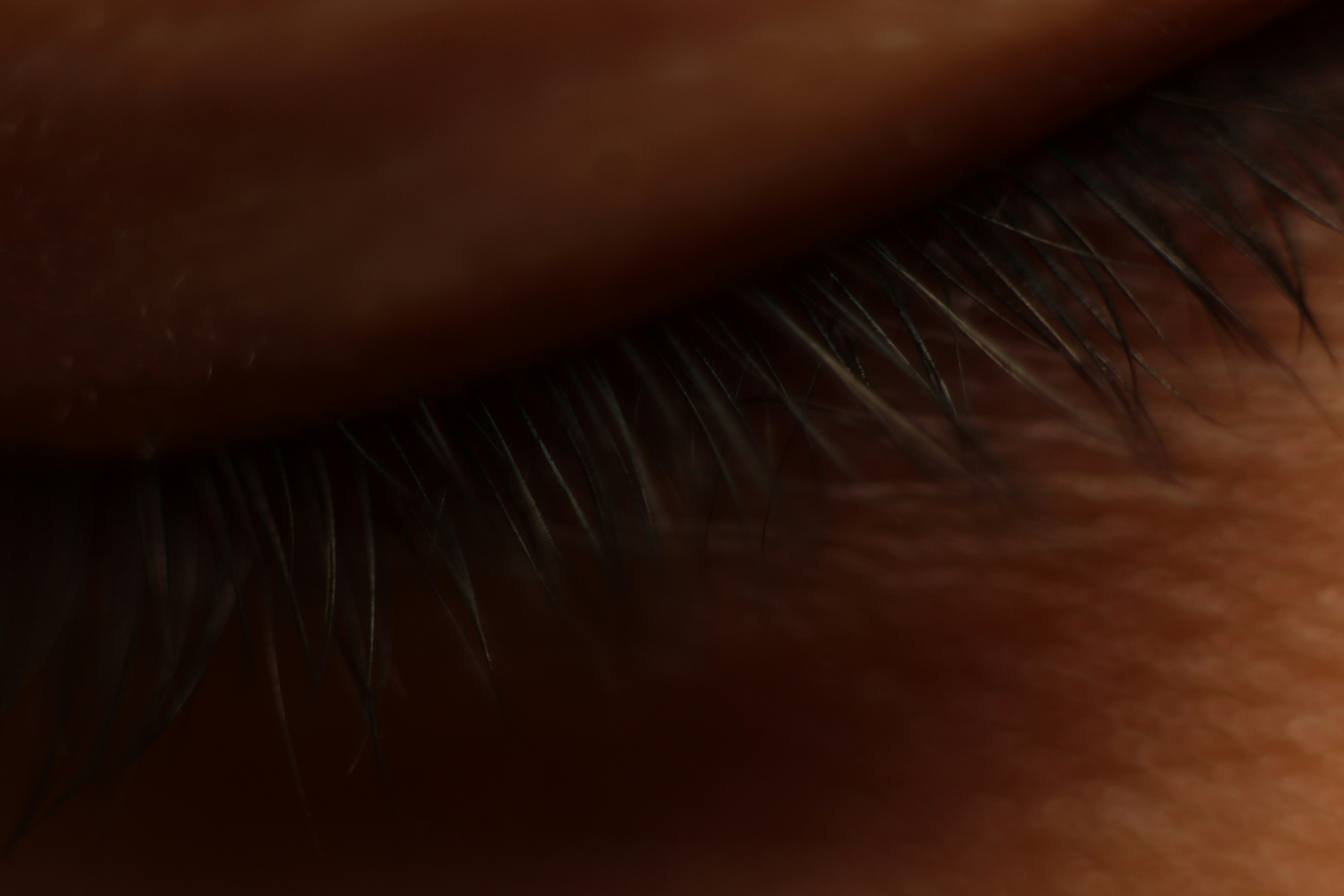 Nahaufnahme dunkler Wimpern auf der Haut