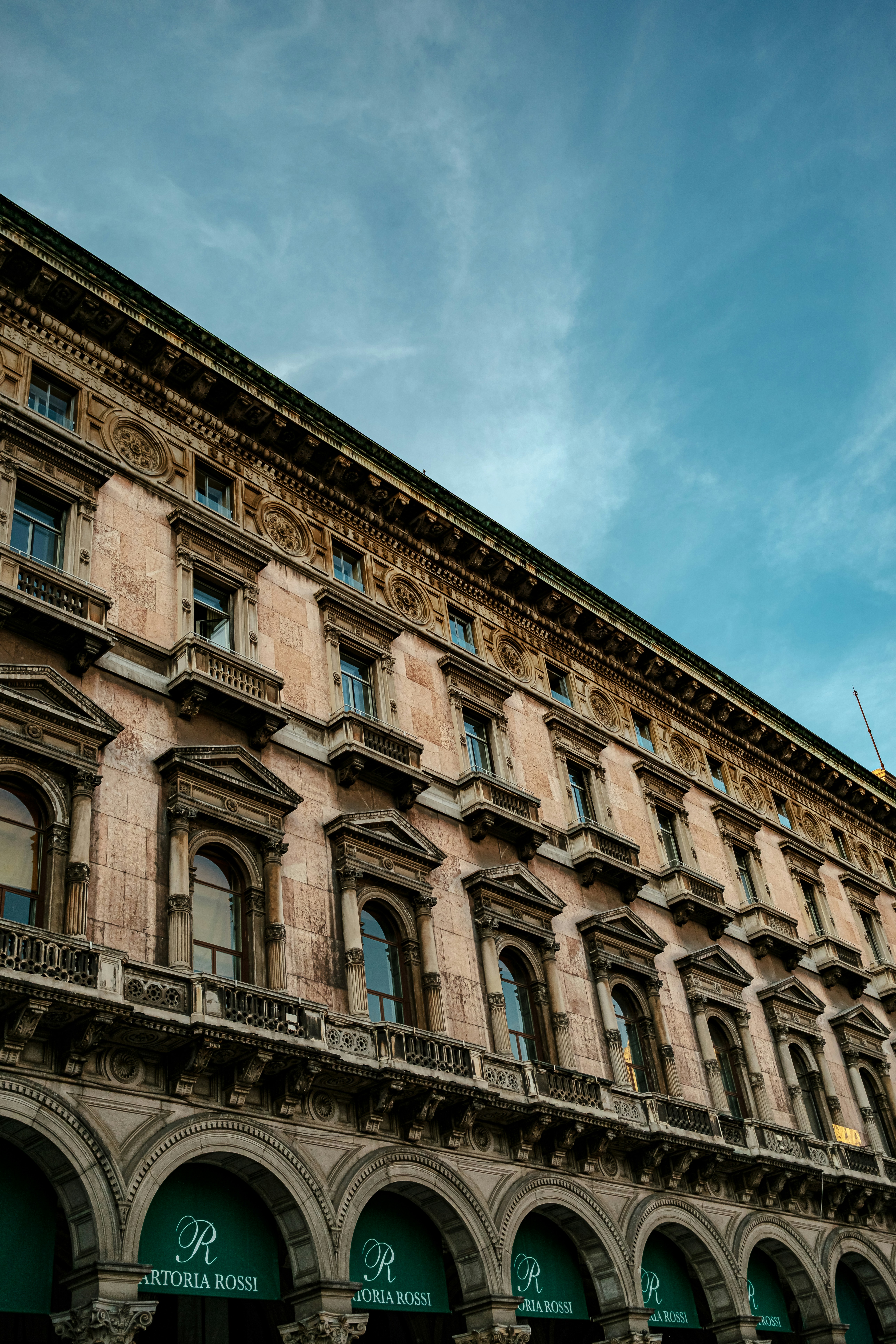 Façade ornée du bâtiment avec entrées et fenêtres en arc