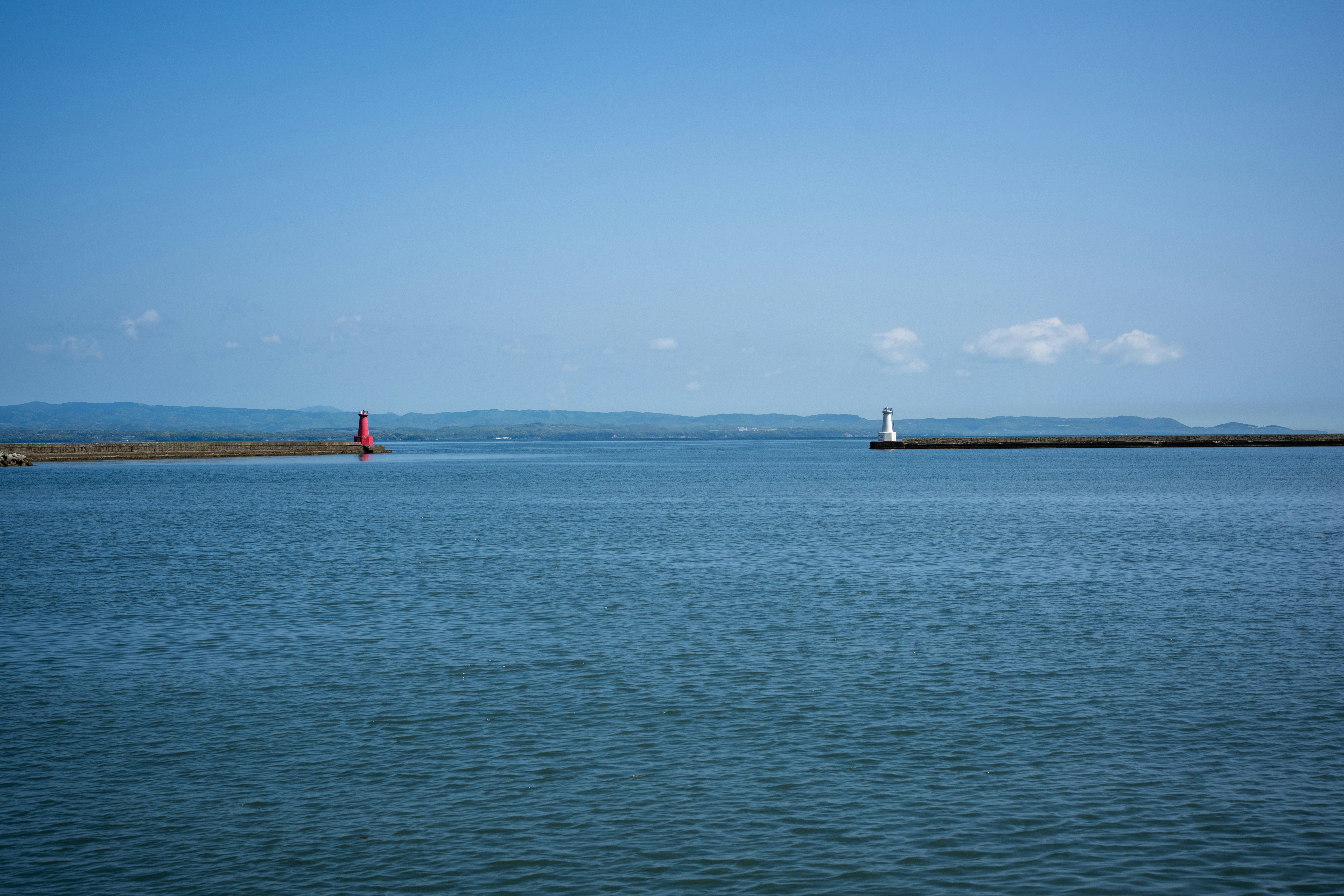 Calm blue ocean with a lighthouse and buoy