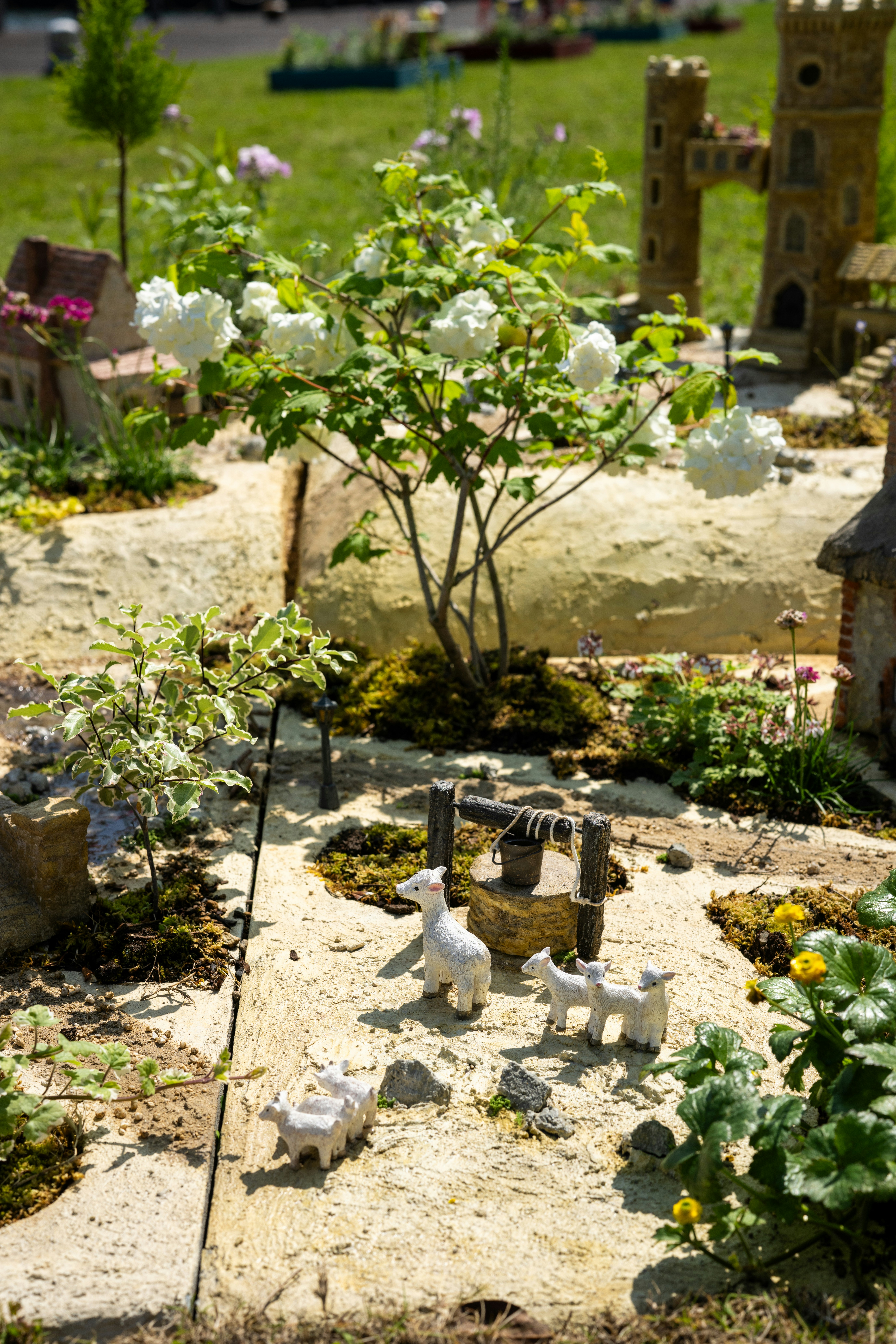 Miniature village scene with sheep and a well