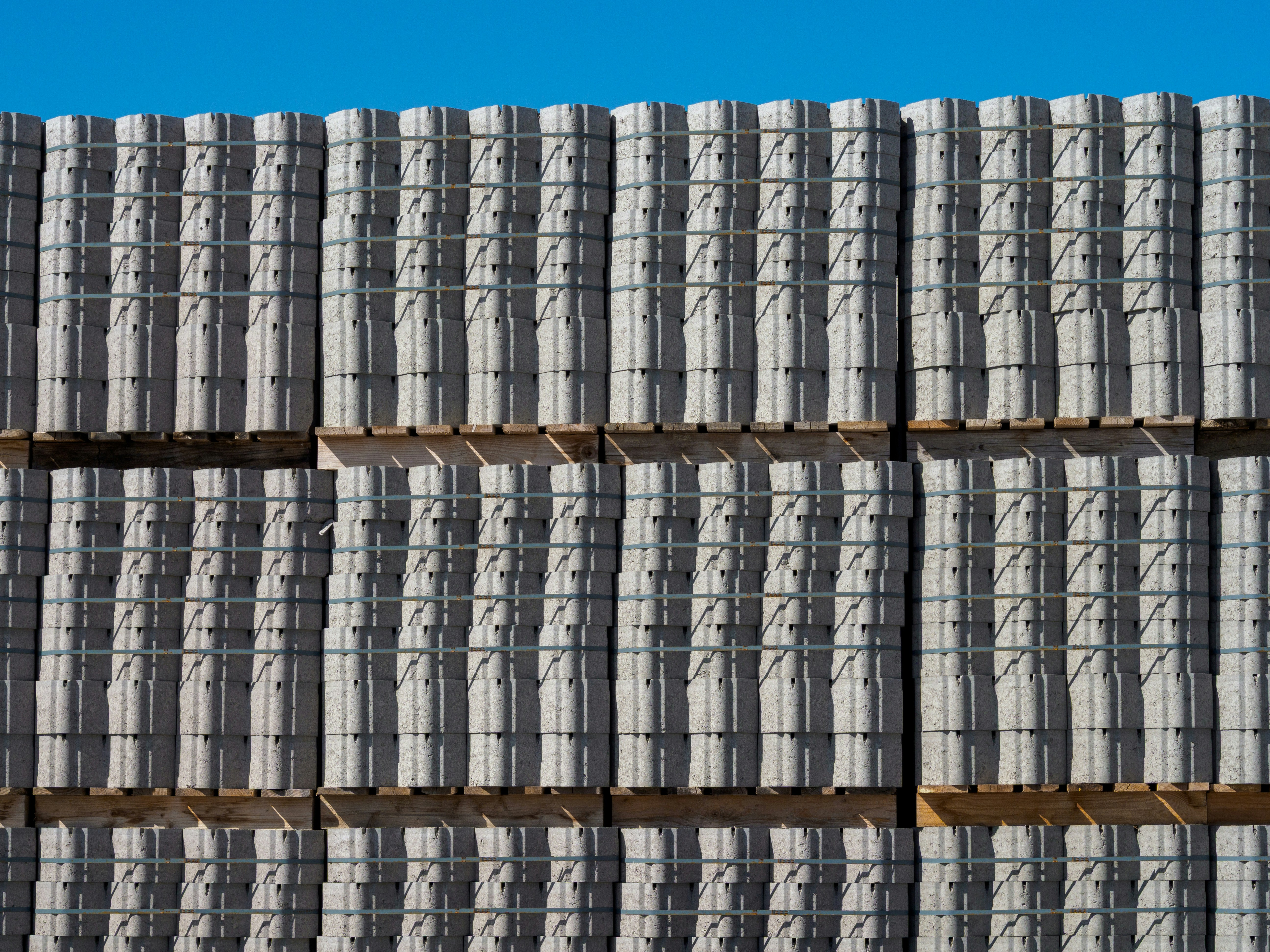 Stacks of grey concrete blocks under a blue sky