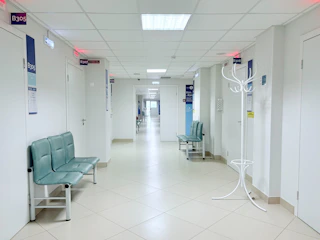 Empty hospital corridor with benches and doors