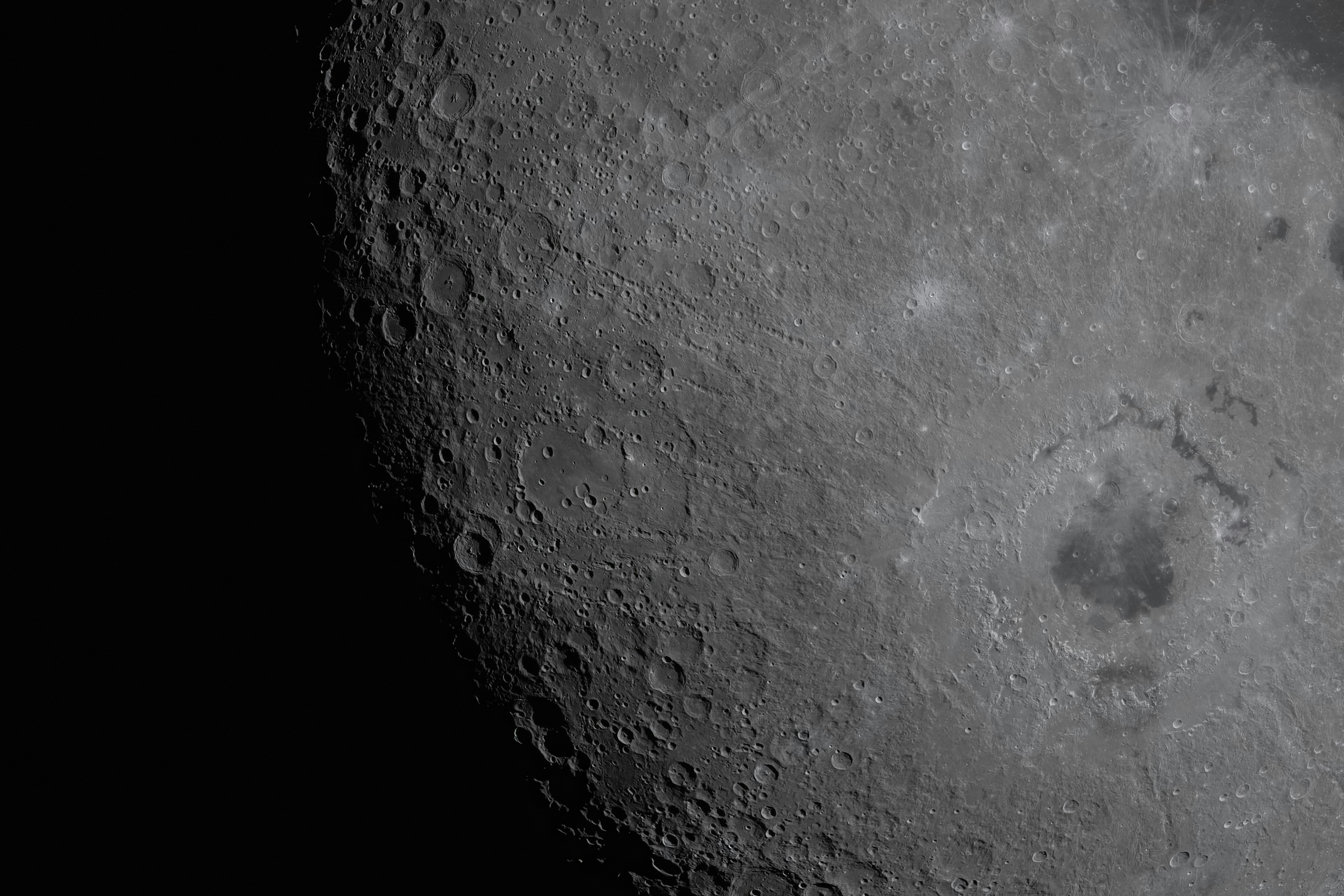 Surface of the moon with craters and dark shadows