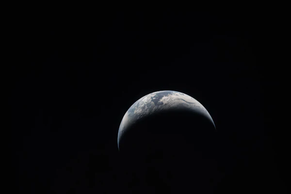 A thin crescent of Earth seen from space against the darkness, the whole planet the Kp index describes