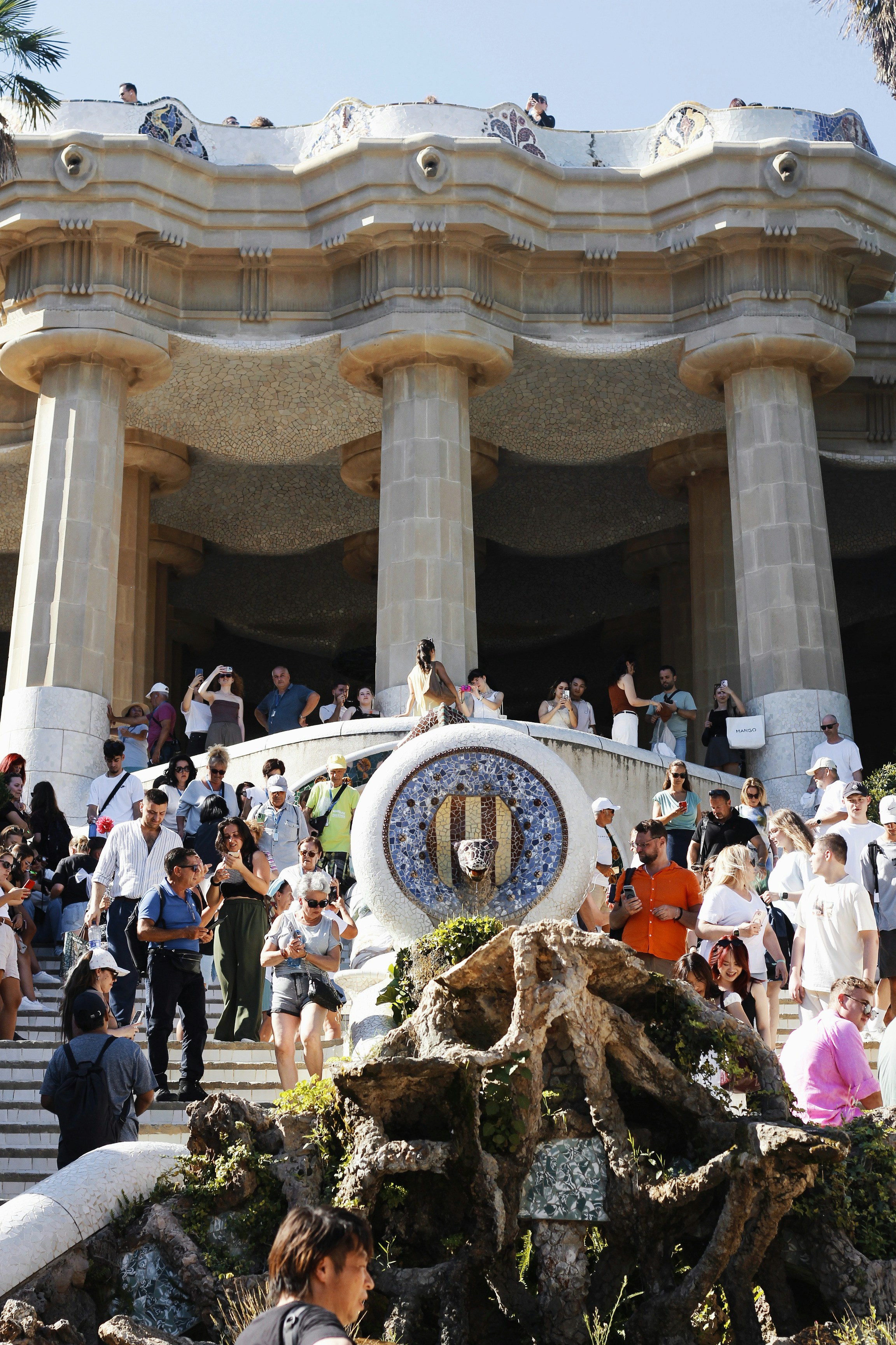 Les gens se rassemblaient à l’entrée d’un grand bâtiment orné.